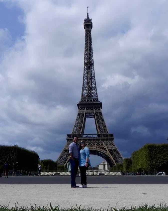 Travel advisor Bijoy standing in front of the Eiffel Tower with female companion