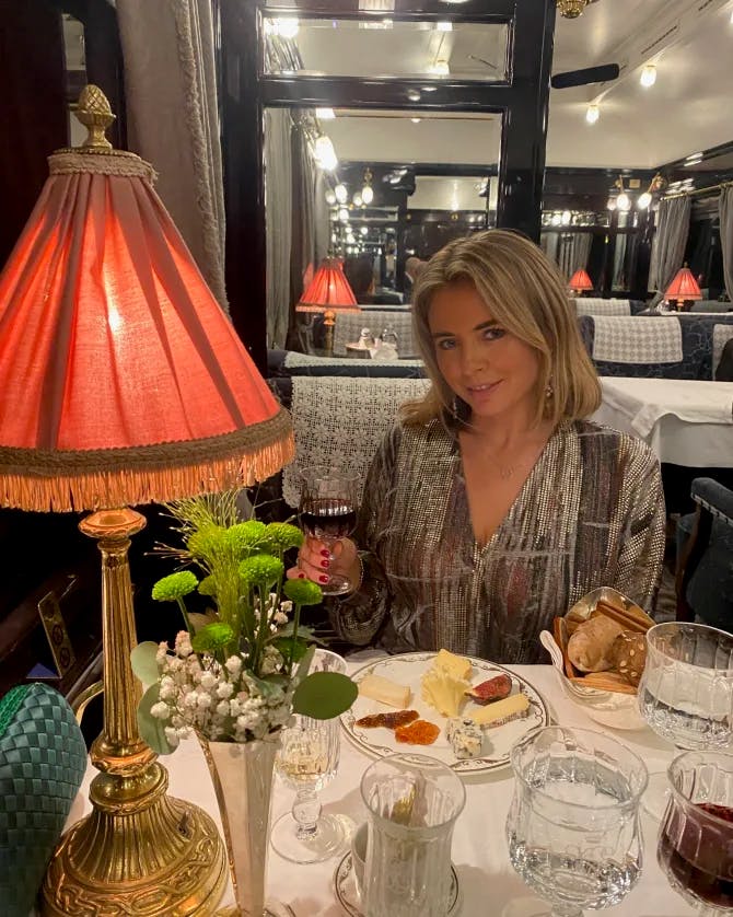 Travel advisor Edwina dining at a restaurant with a red table lamp and white tablecloth