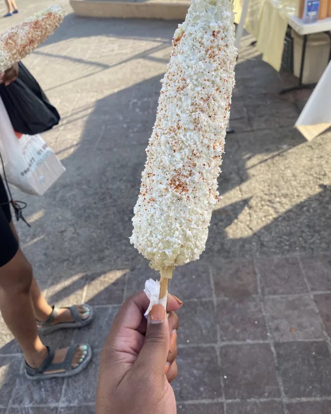 Corn on a stick covered in toppings