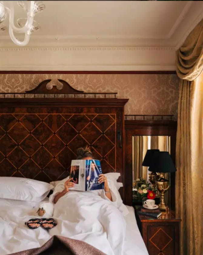 Travel advisor Edwina reading in bed with the book covering her face