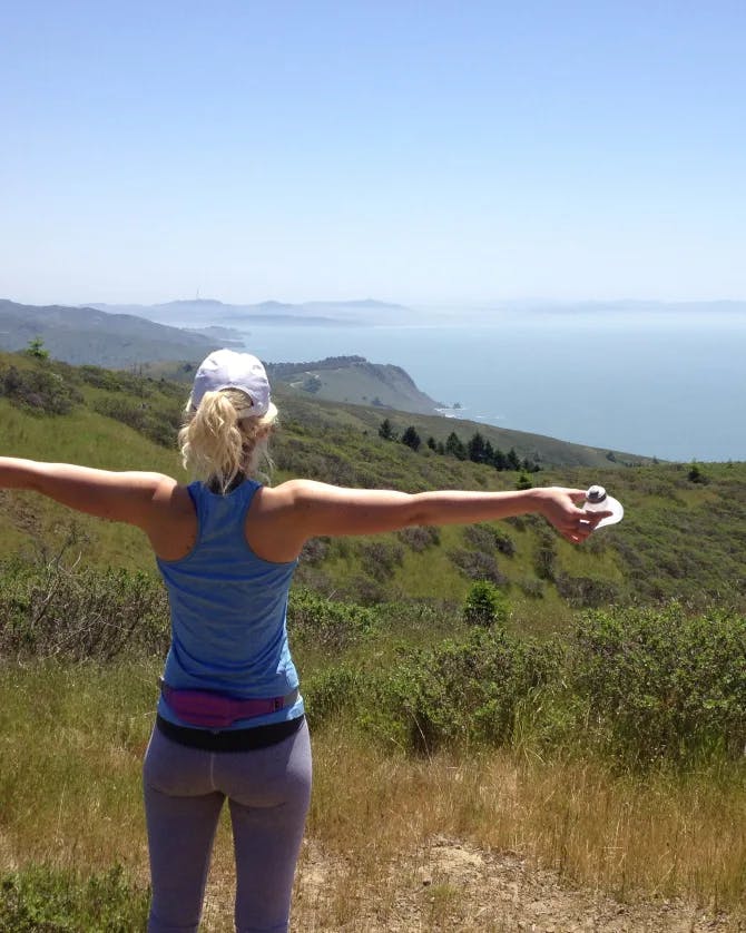 Keller taking a break on the hike to take in the beautiful view of the green hills and the sea