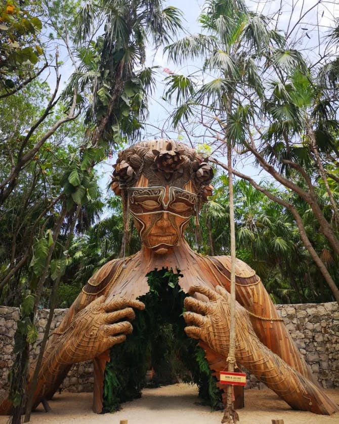 View of a large hollow sculpture of a wooden human figure in Tulum