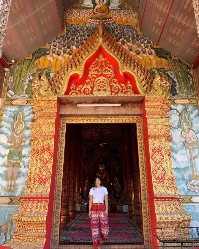 Nicole G posing in an ornate arch way with beautiful colors.