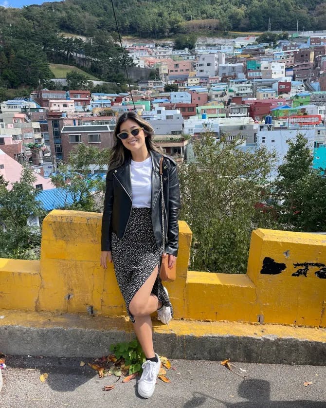 Nicole G posing with an aerial view of the city behind her. 