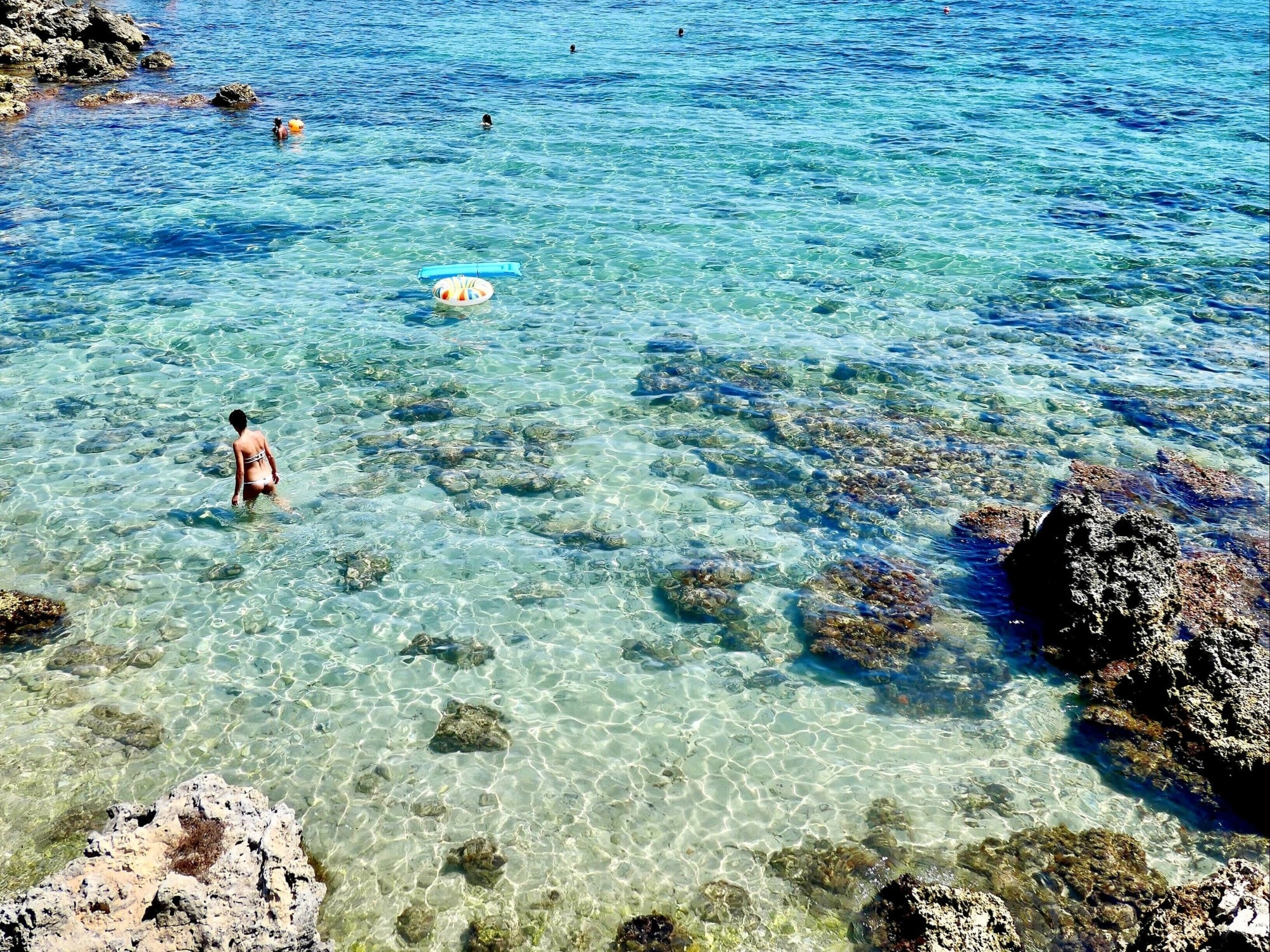 Clear water and beach with people.