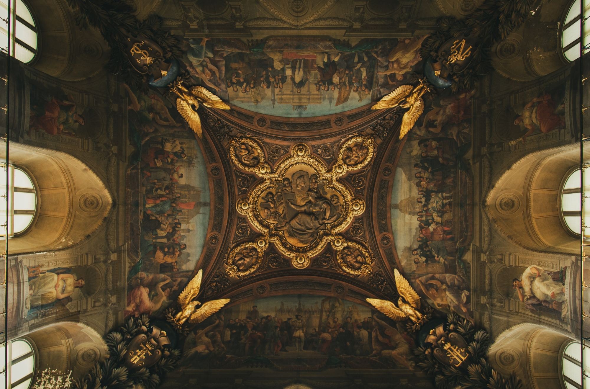 Brown and gold ceiling with painting of people. 