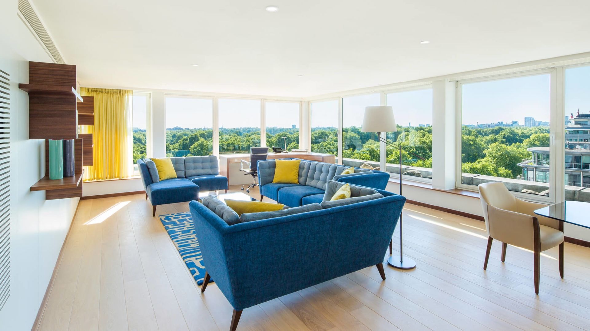 A suite with blue sofas and yellow cushions. 