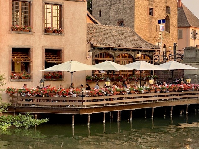 People dinning on an over water deck of a restaurant in France