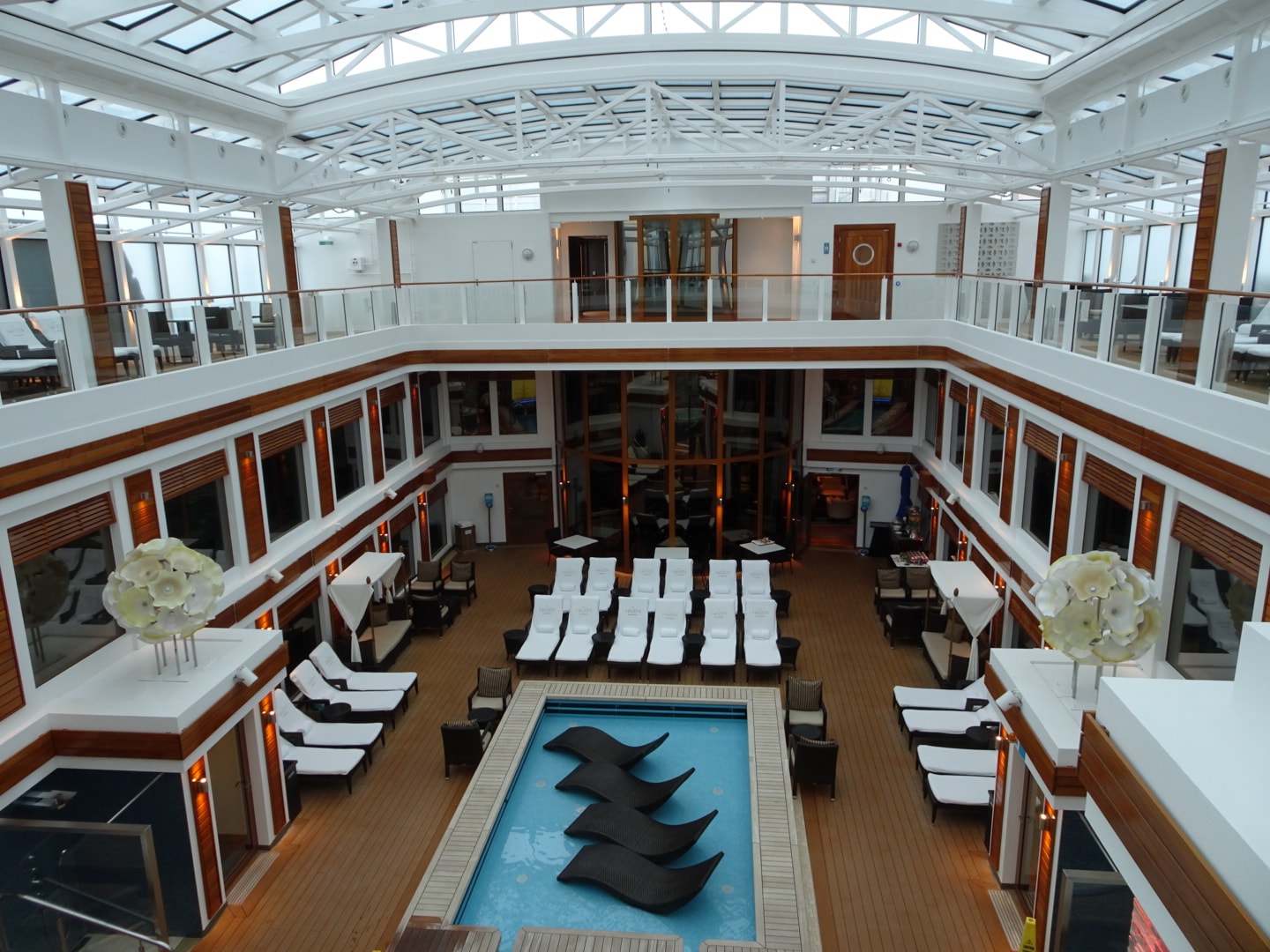 indoor pool deck surrounded by balconies and pool chairs