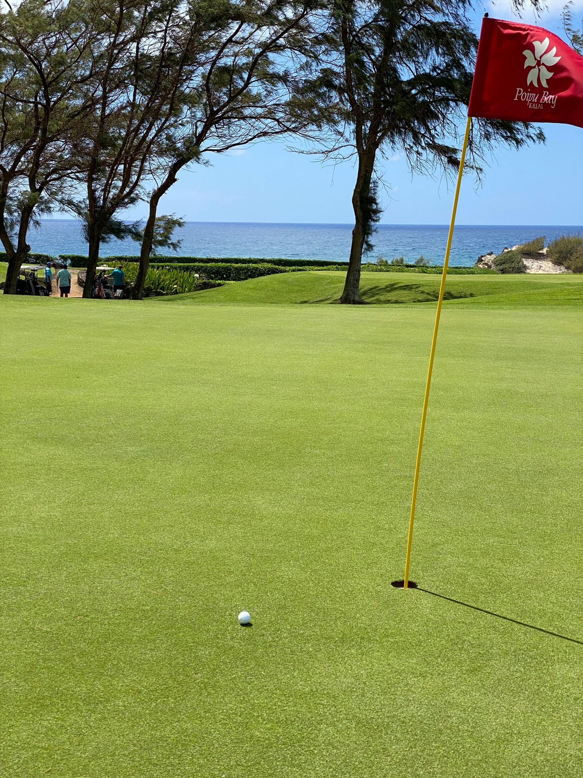 A golf course with water body at the back. 