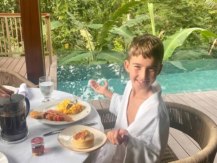 Boy in white dress enjoying his food