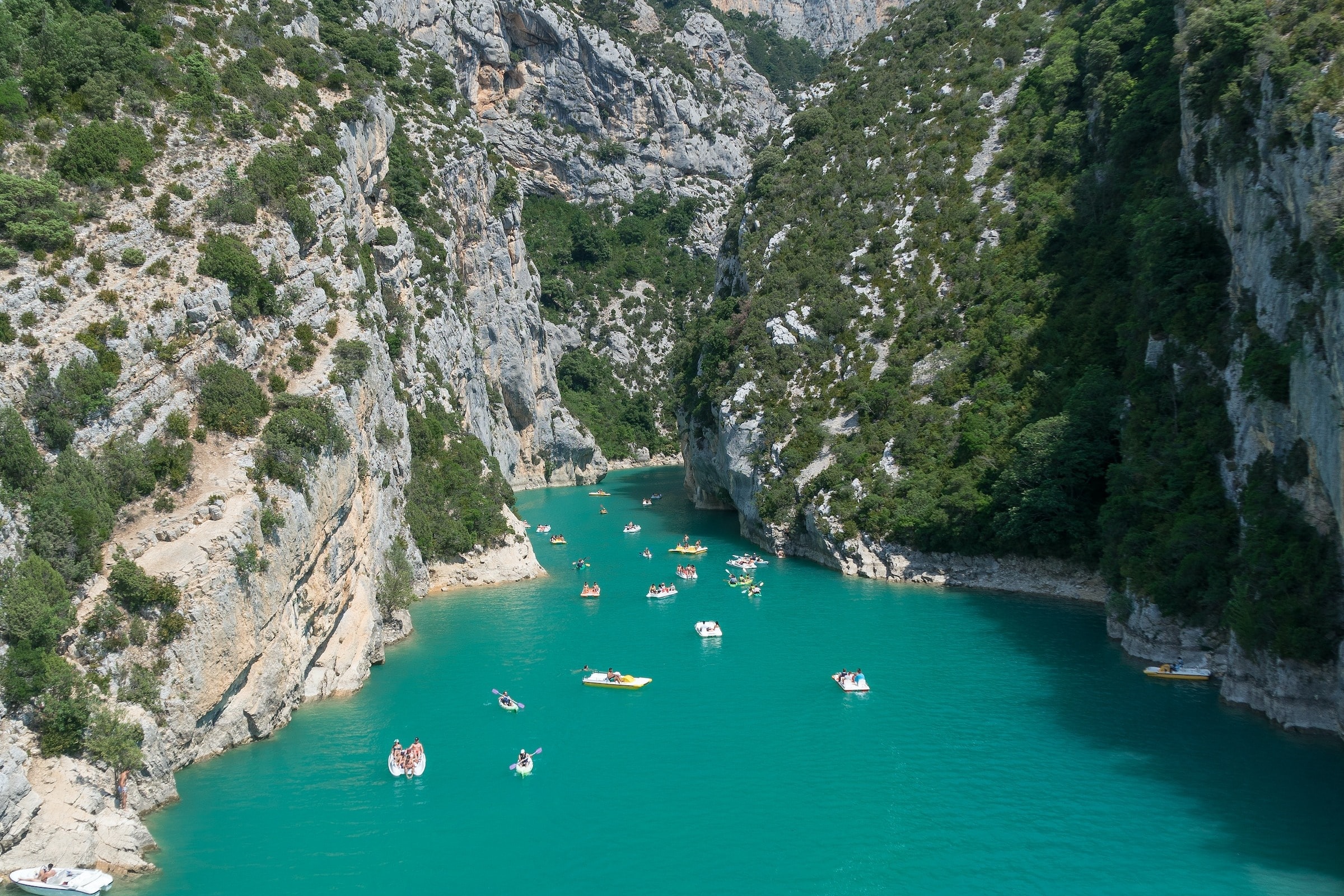 Boats on Lac de Sainte-Croix near mountain view.