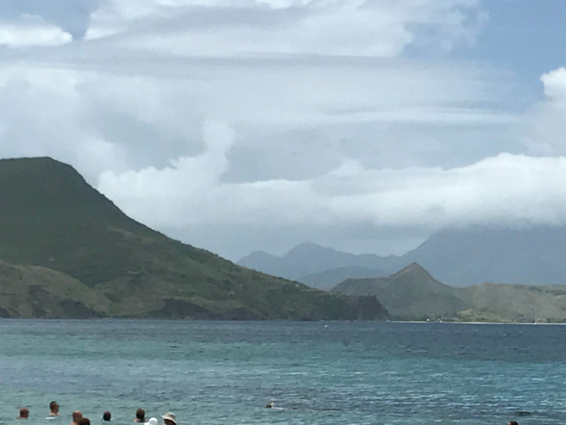 View of the sea, sky, and mountains on a semi-cloudy day.