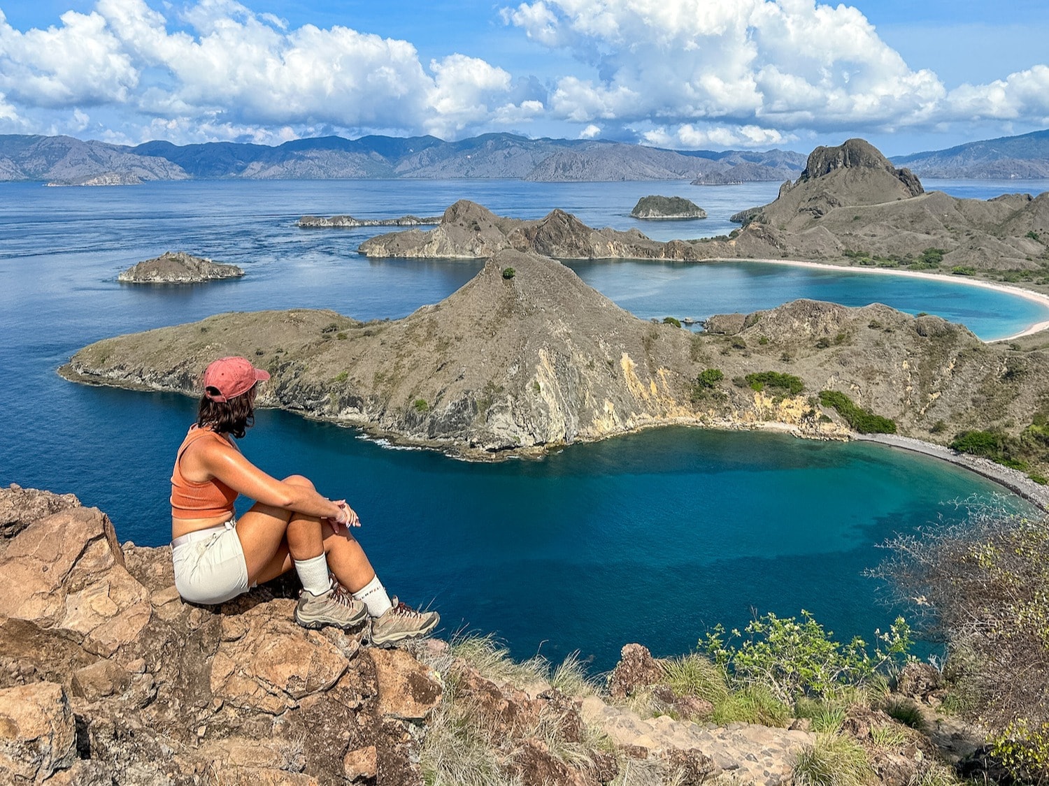 A women looking over a waterbody with small hills. 