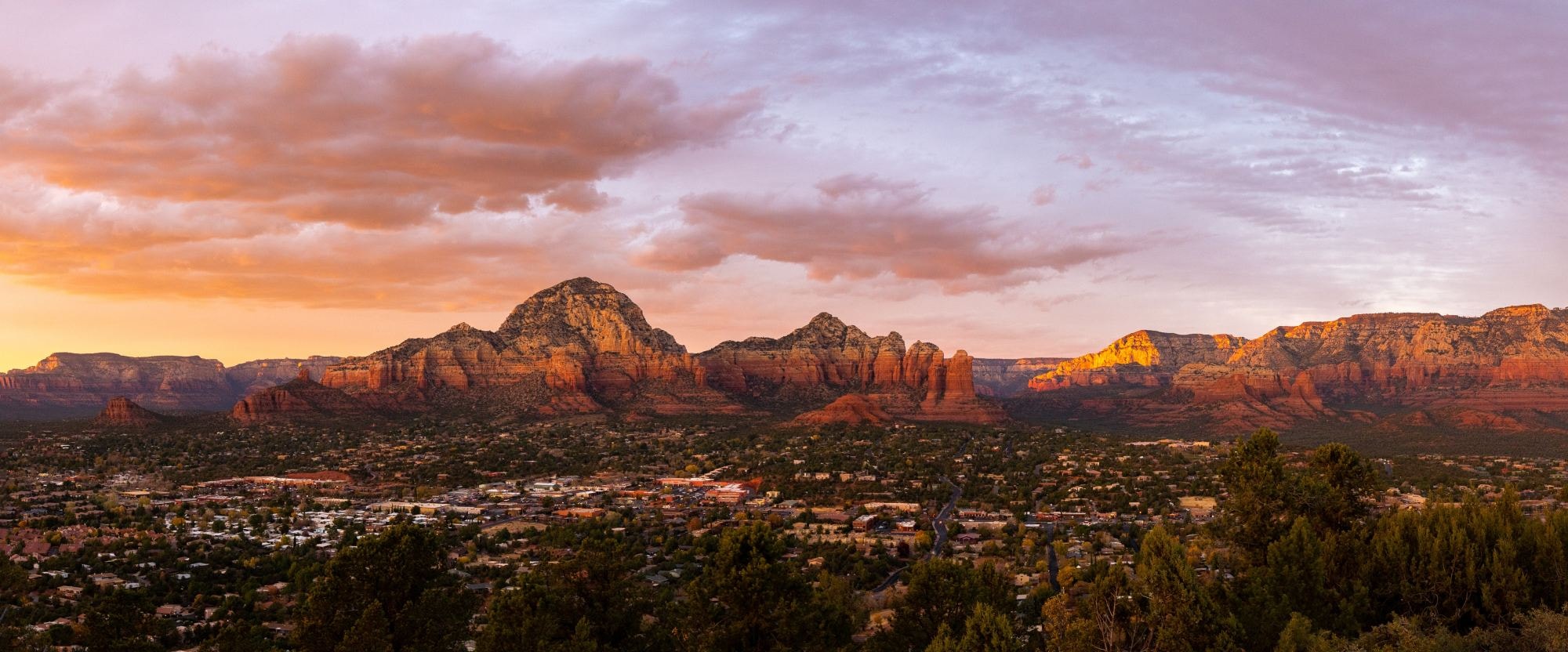 City view with red mountains at the back during orange hour. 