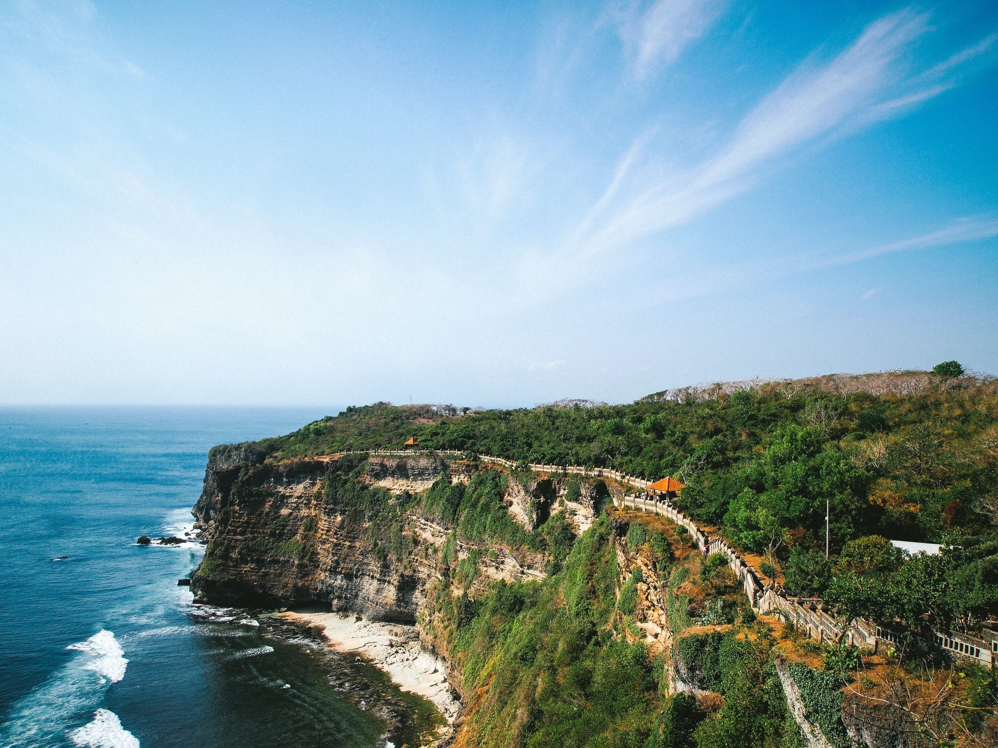 an ancient temple stretches along a cliff over the ocean on 