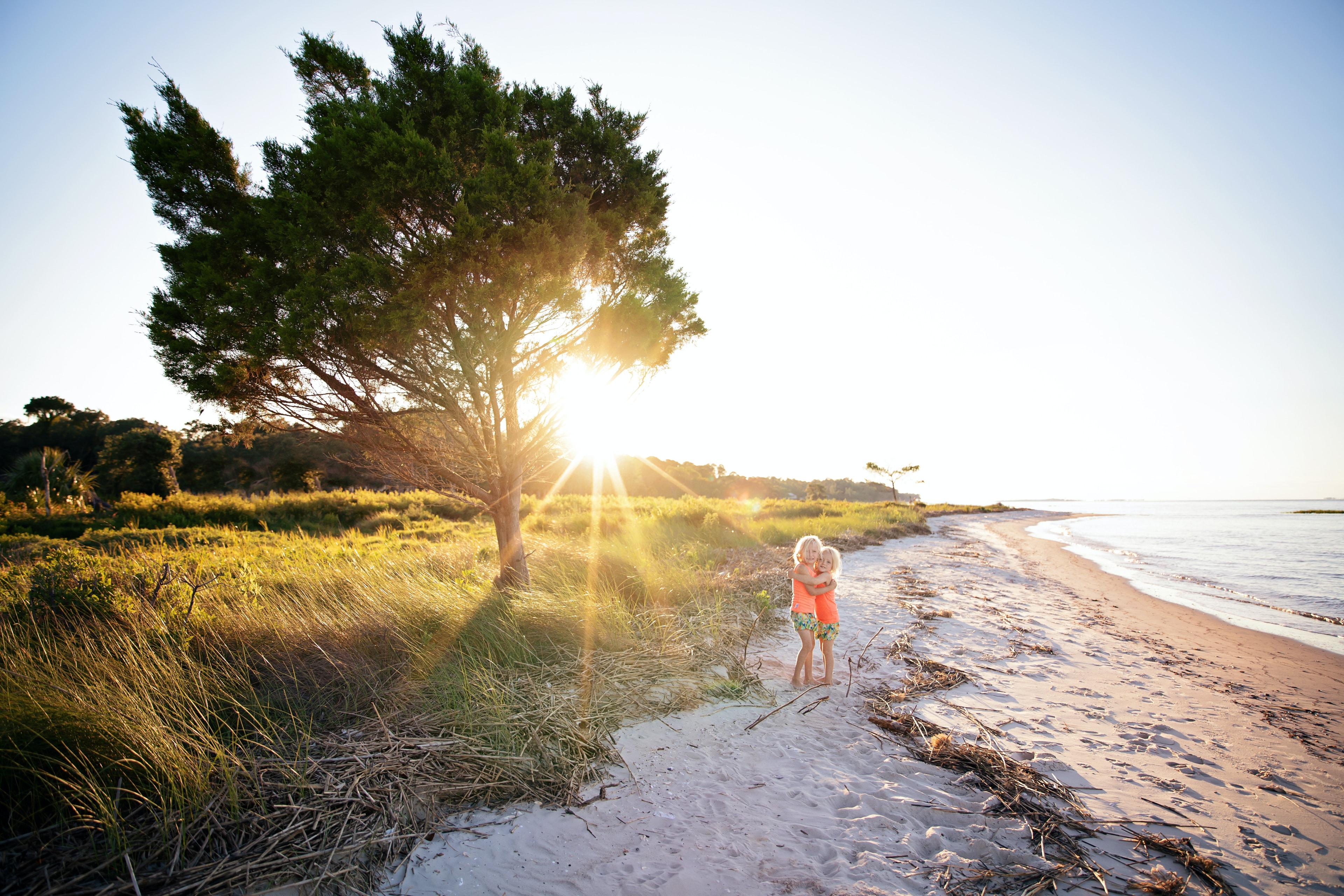 A picture of kids posing near a beach during daytime hours