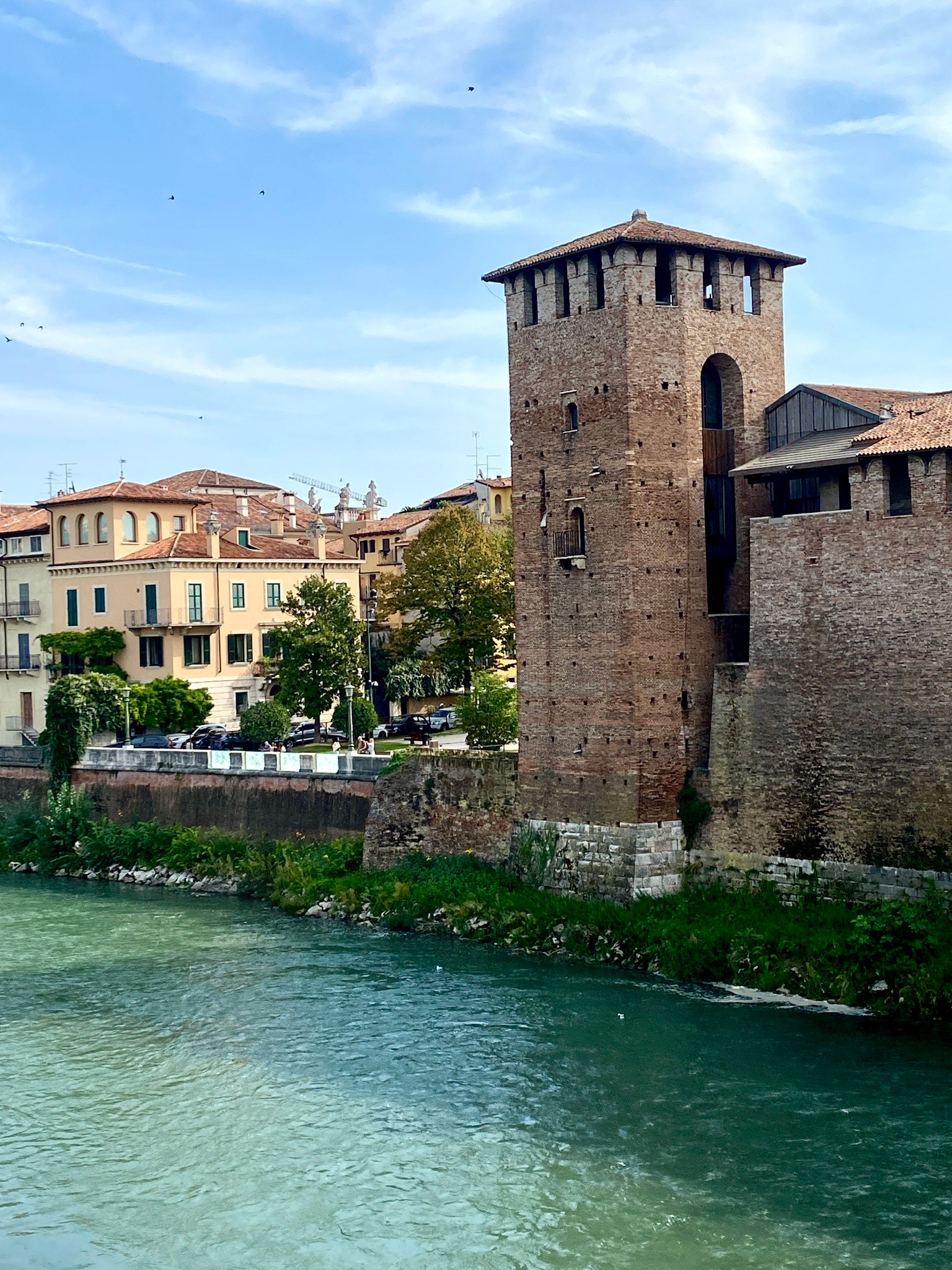 A picture of the canal during day time with buildings and a town in the distance.