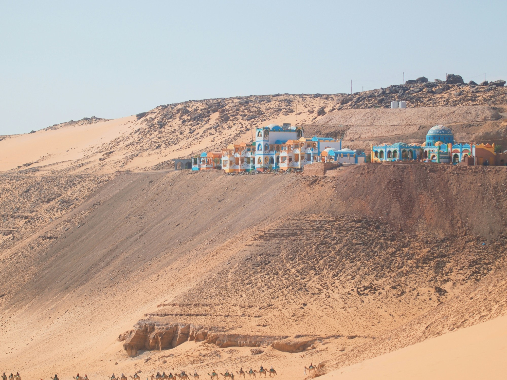 A group of buildings on a hill in desert. 