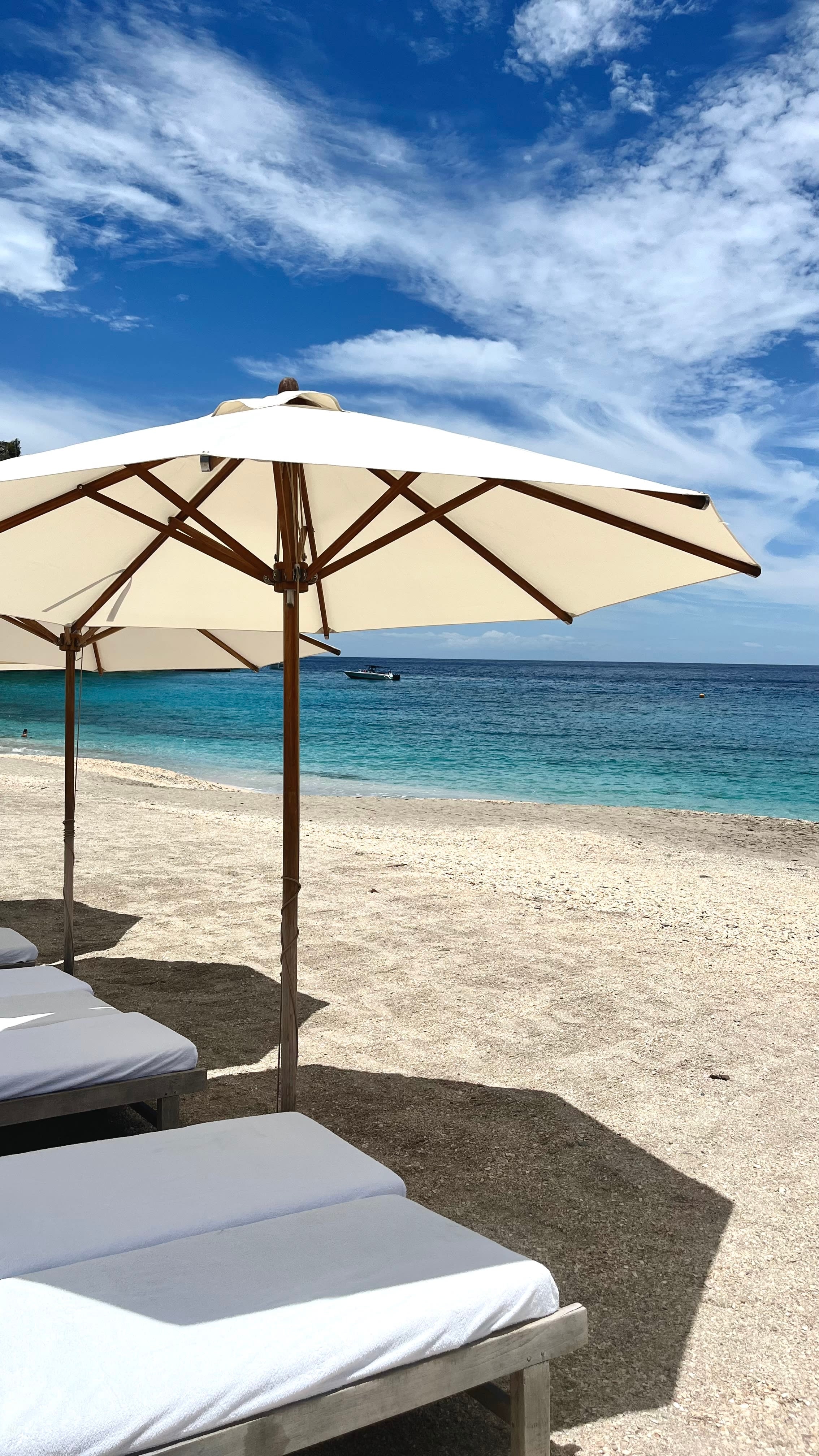 A beach with beach chairs and umbrellas.