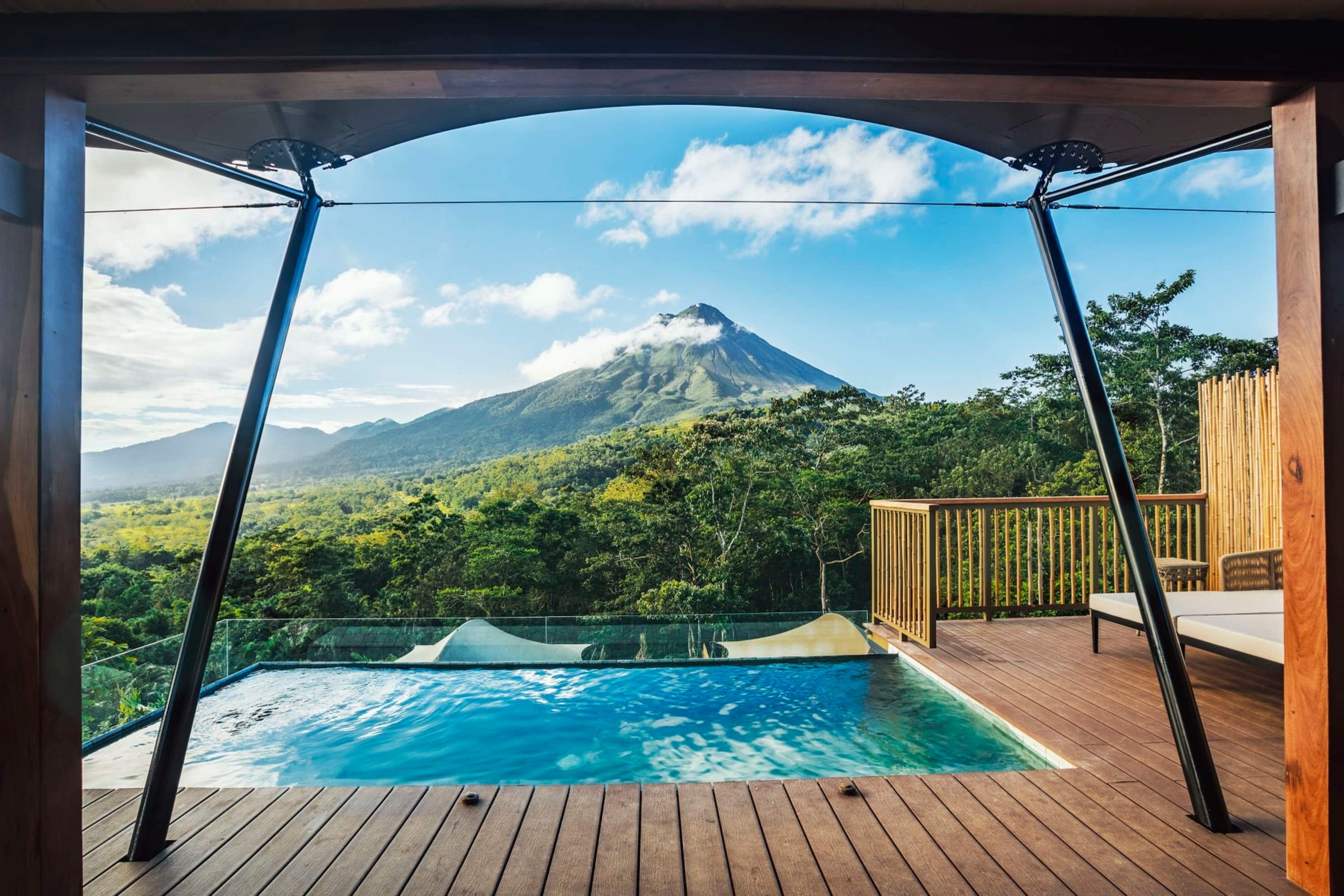 A large private balcony with a plunge pool, canvas awning and loungers, all with an incredible view of Mount Arenal