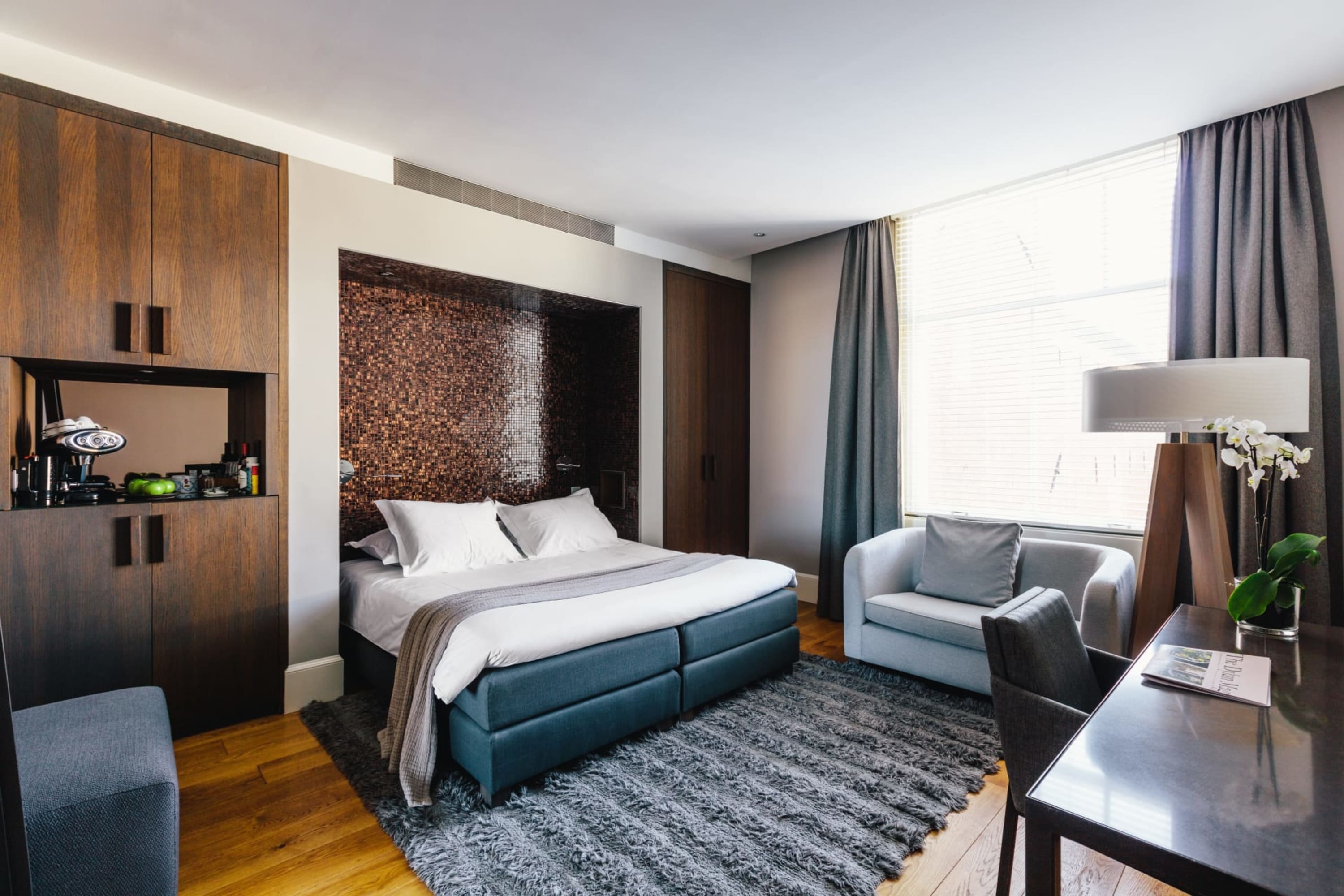 Dark wooden accents, chic decor and furniture in a contemporary-style hotel room