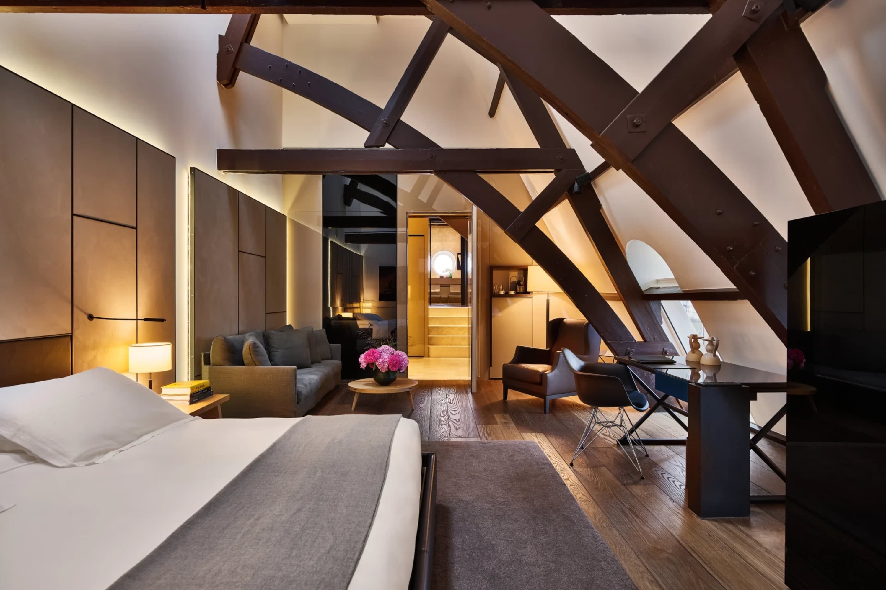 Design-forward hotel room with chic furniture, vaulted ceiling a bold floral arrangement for a sudden pop of color