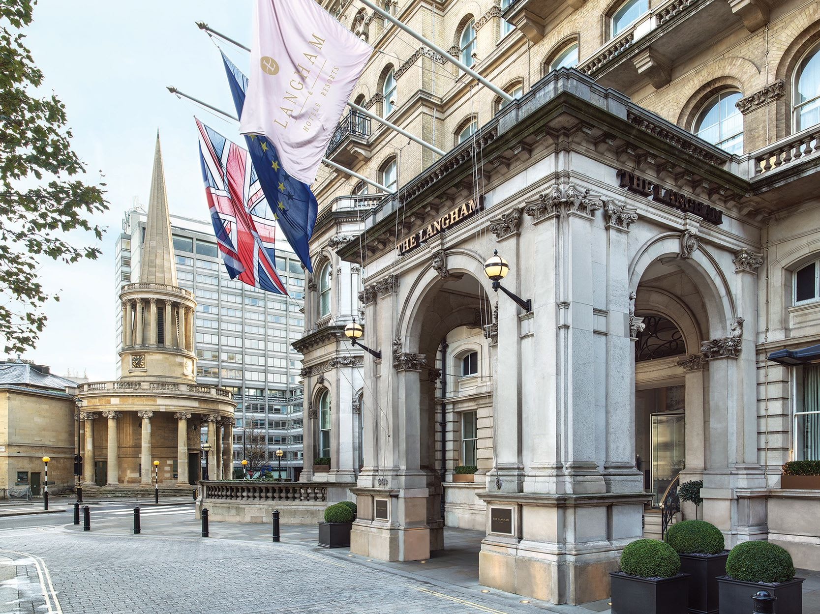 Grand entrance with stone arches and flags flying overhead.