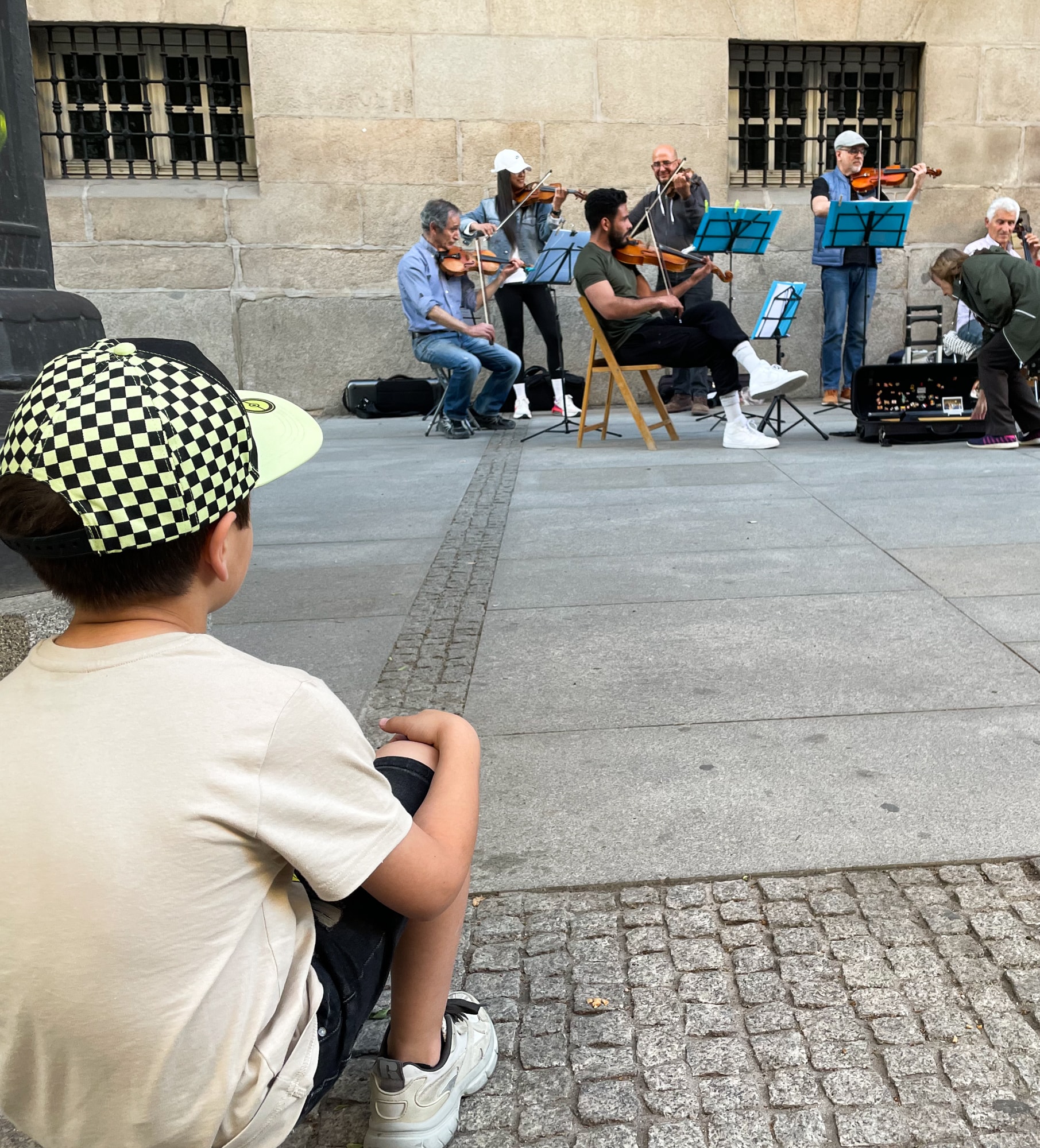 A child watching a live music performance on the street