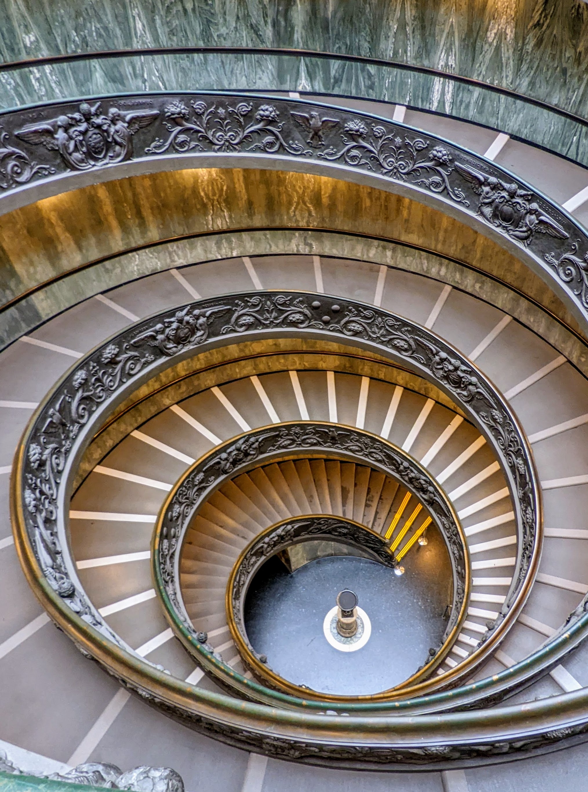 A beautiful classic spiral staircase with stone steps and magnificent lighting.