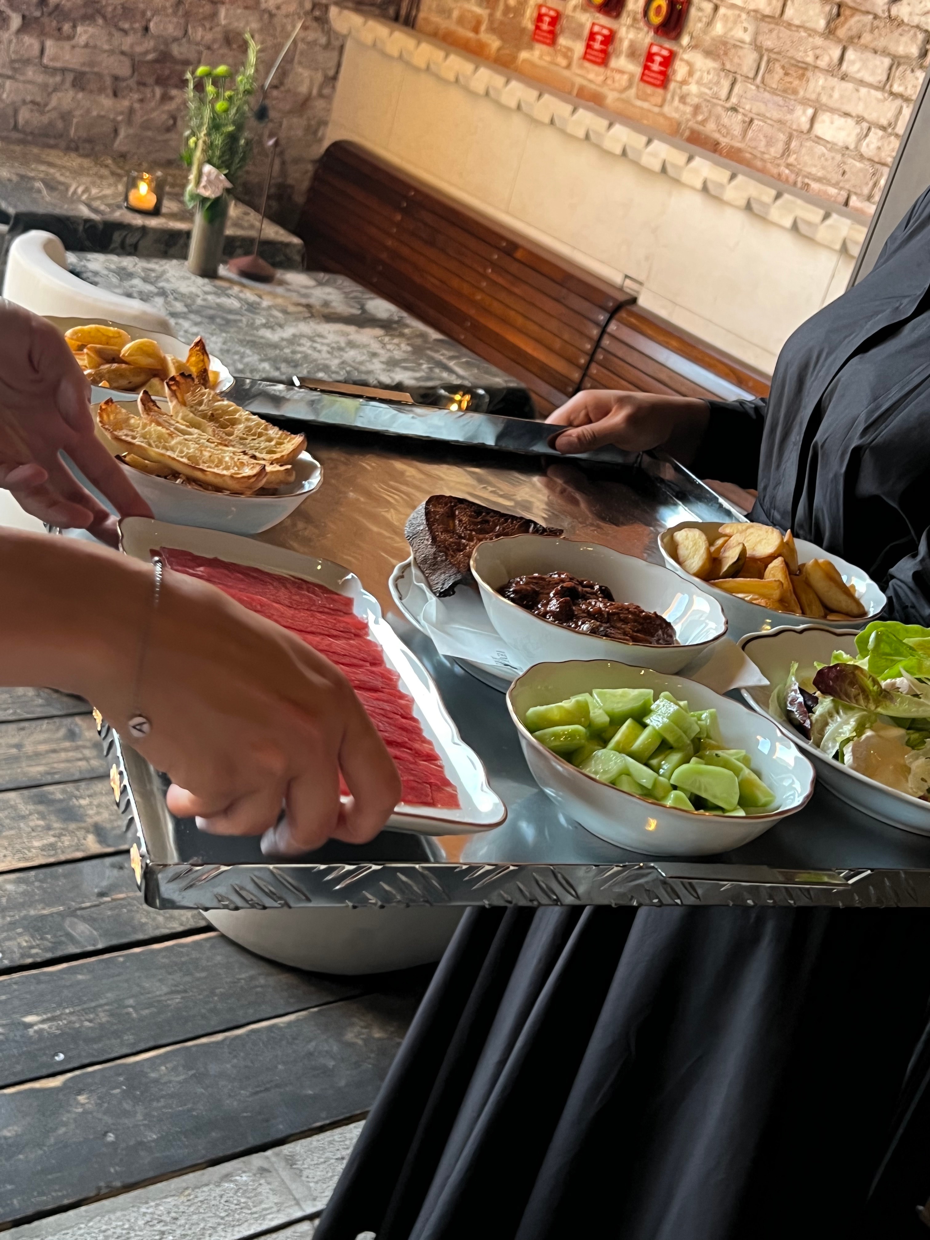 A delicious spread of food being served on a sterling silver tray and lovely restaurant in Venice. 