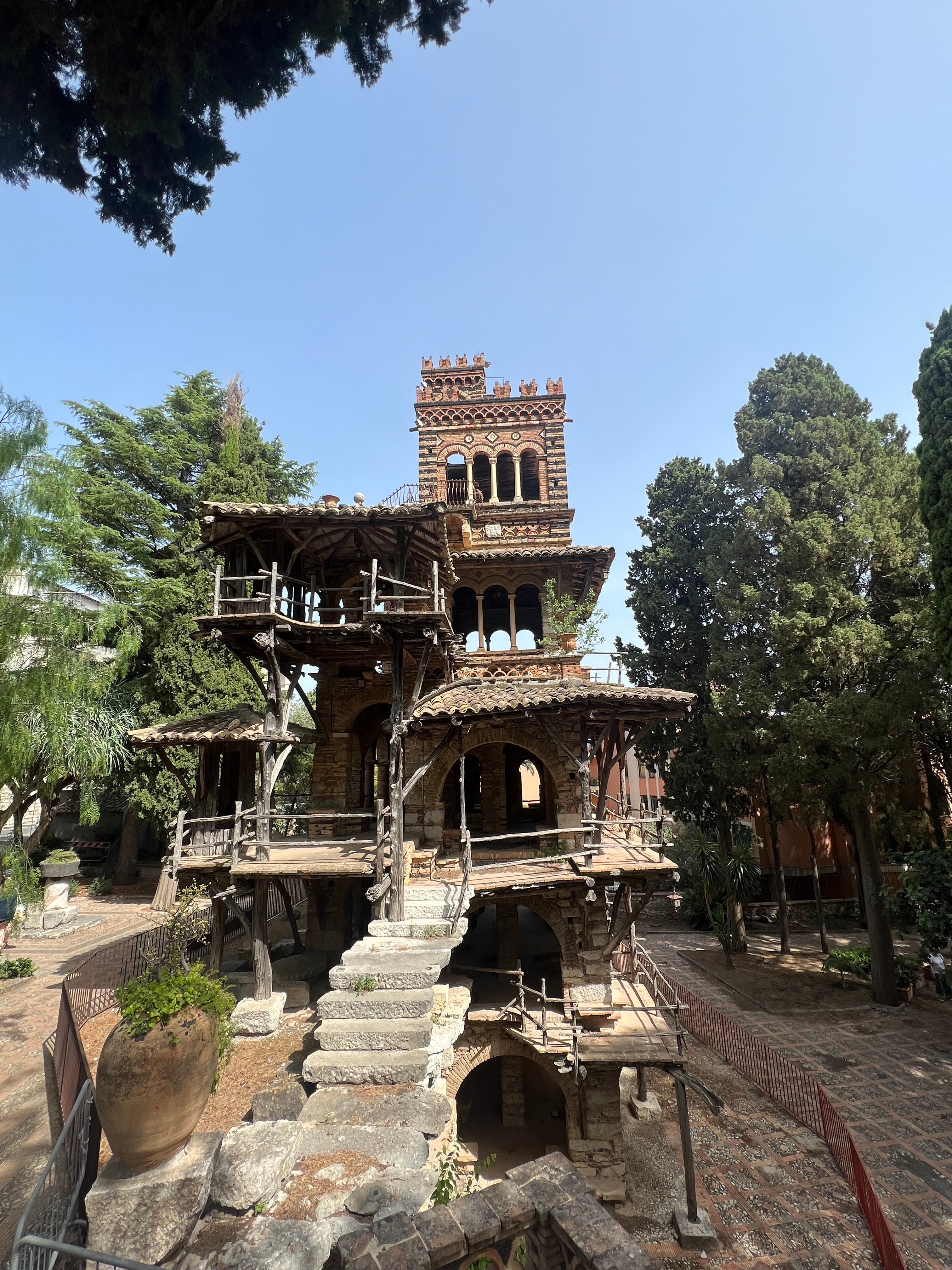 A beautiful view of an old structure in Italy with foliage surrounding on a sunny day. 