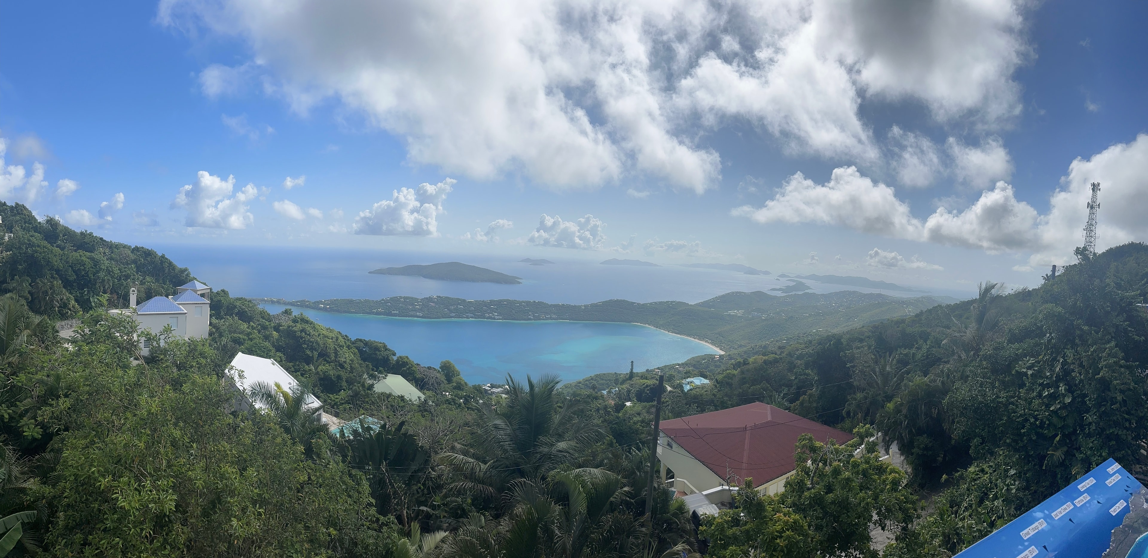 An image from high above a valley with a lake in the distance and foliage surrounding.