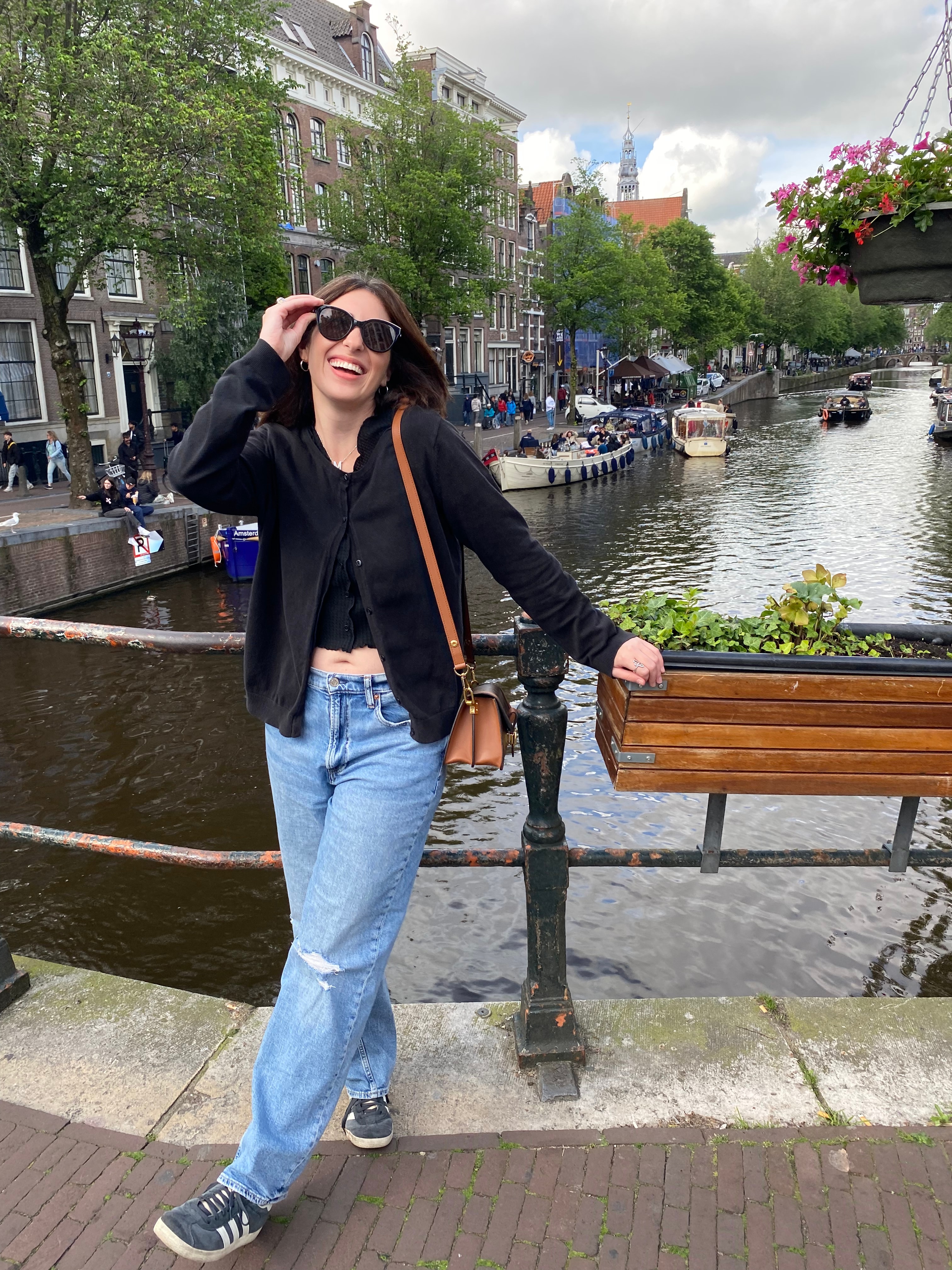 Advisor posing on a walkway over water with flower boxes on a sunny day. 