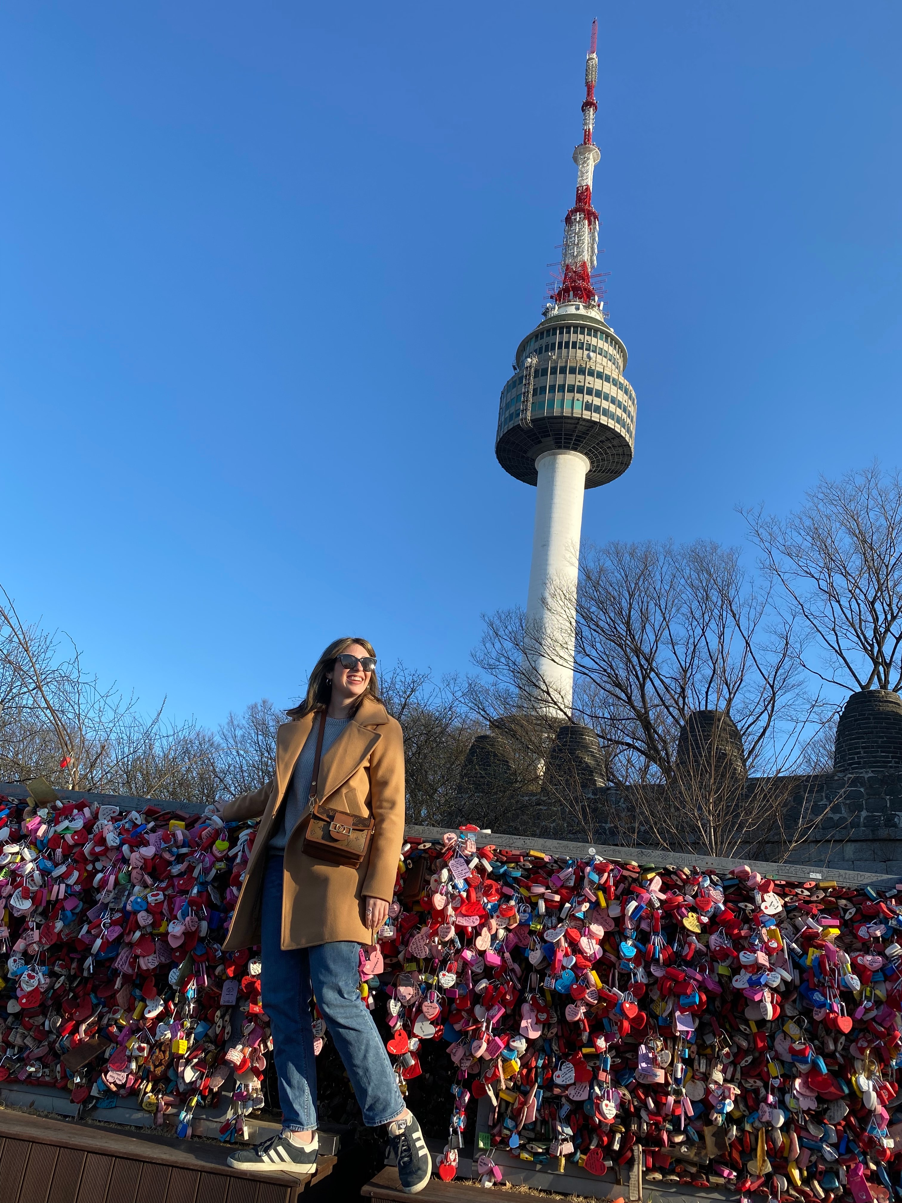 Advisor posing on a bridge with a tall structure in the distance. 