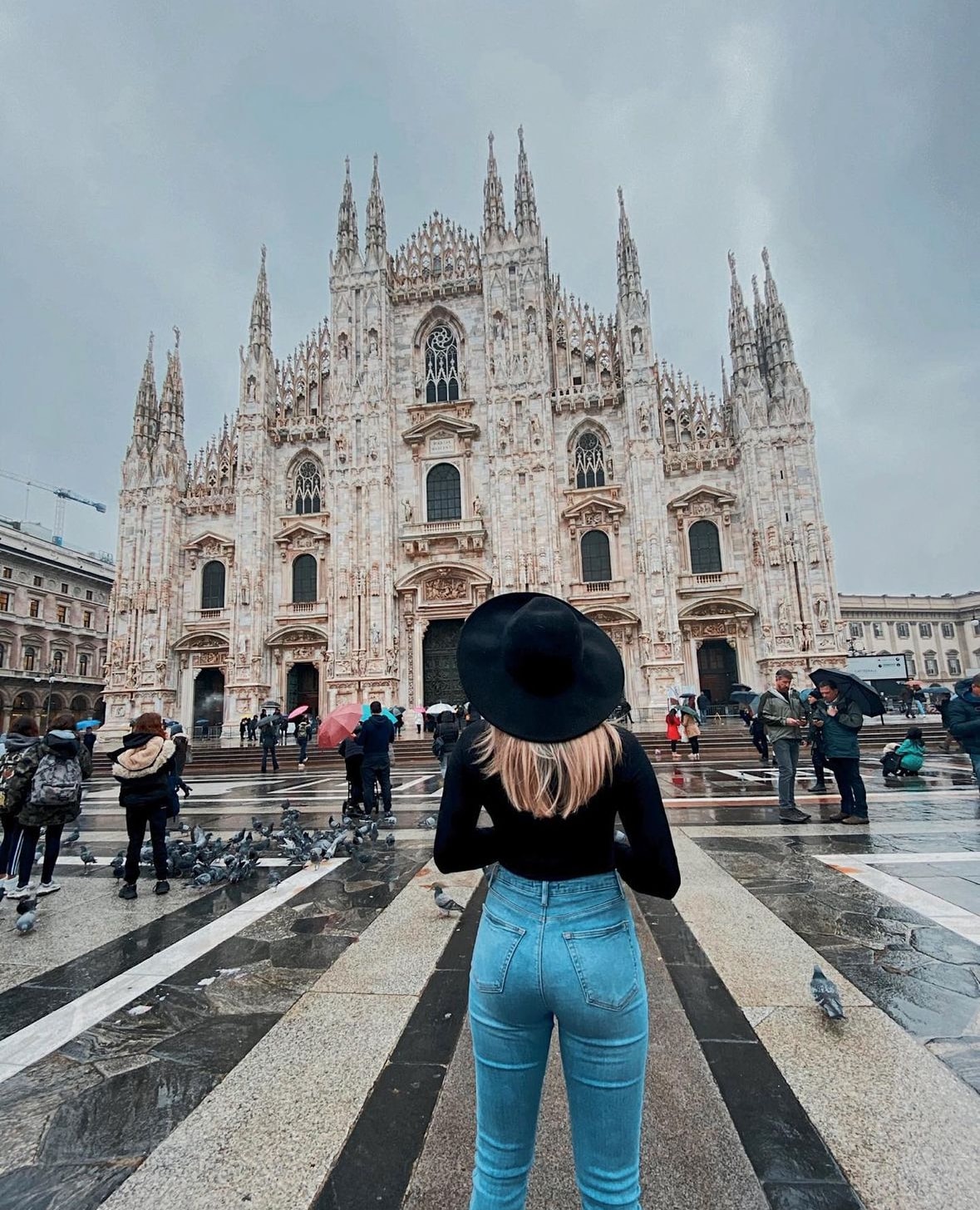 Advisor posing with a church in the distance on a cloudy day.