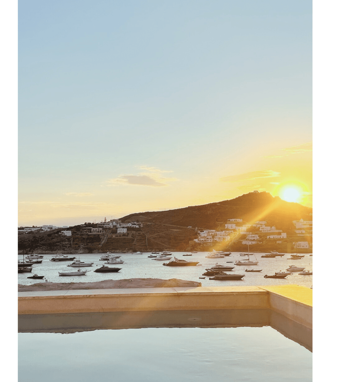 Image of sun setting over a mountain range in a snowy region. 