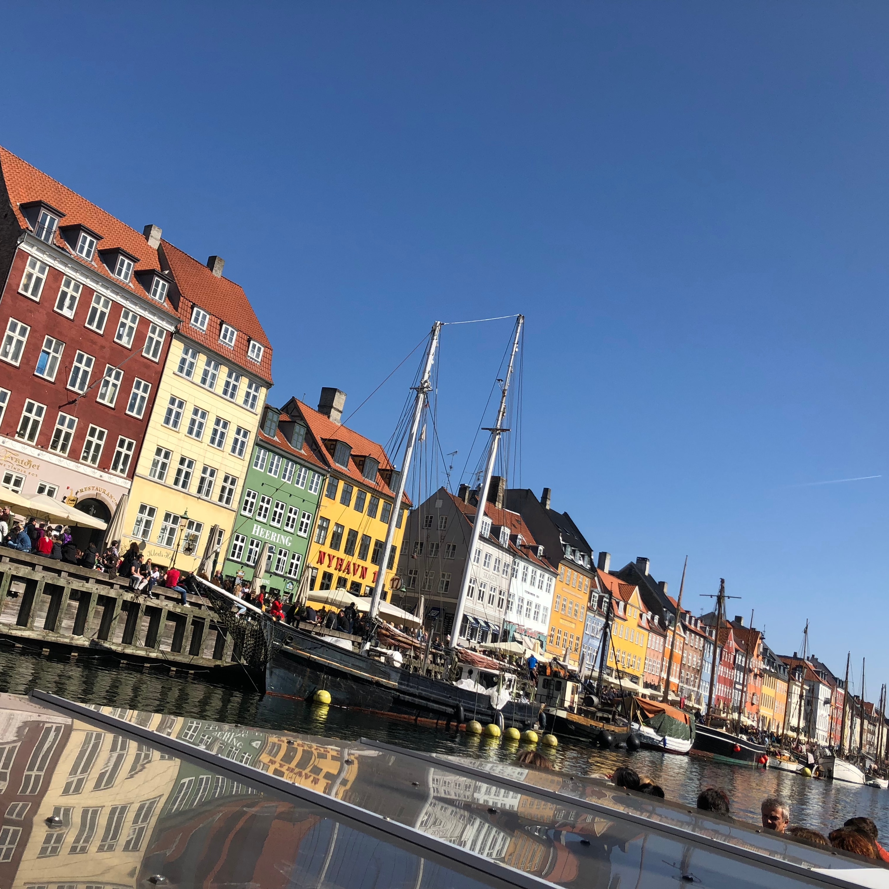 View of colorful buildings and boats along a canal in Copenhagen on a sunny day