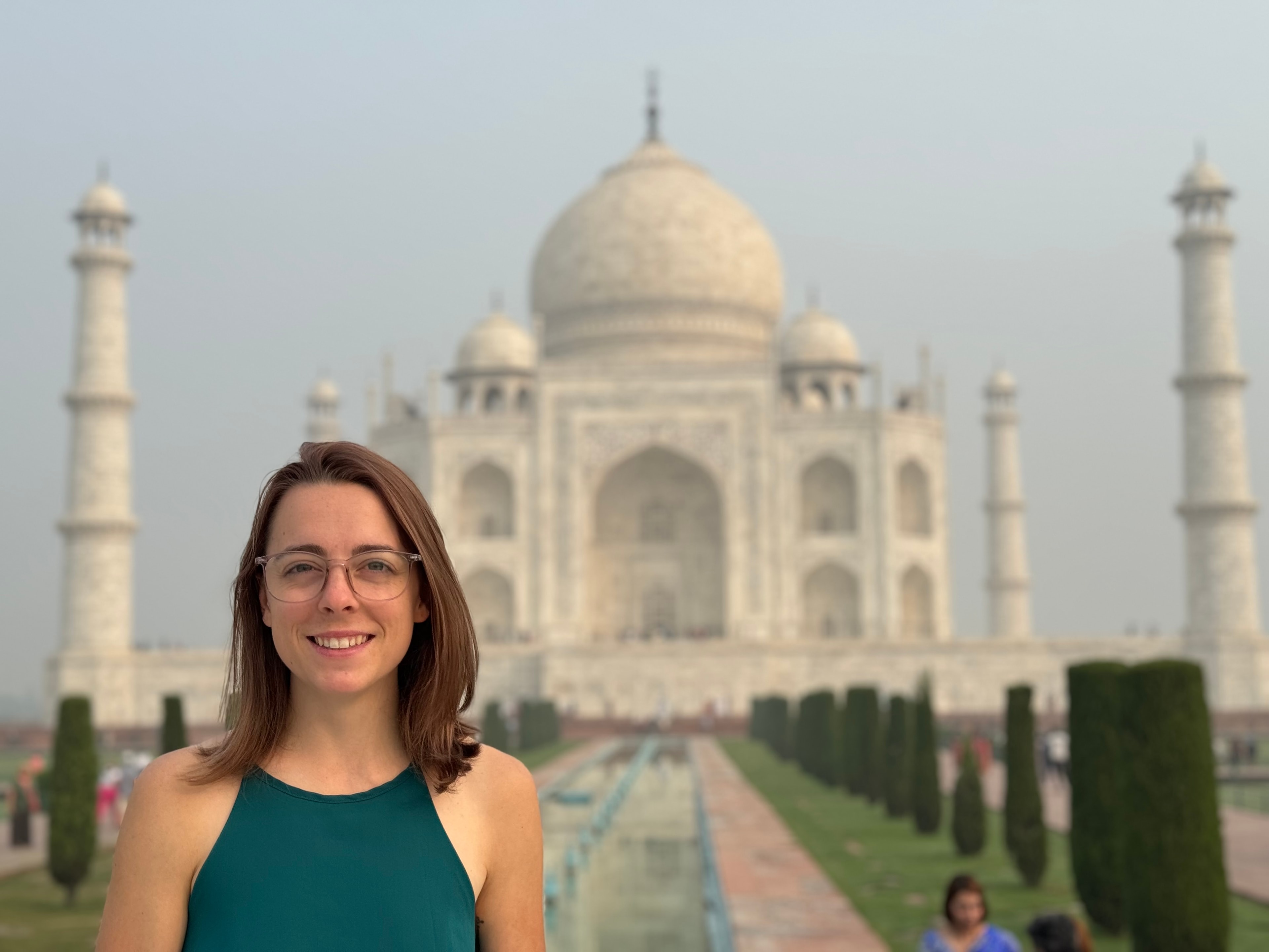 Advisor posing for an image on a sunny day with the Taj Mahal in the background. 