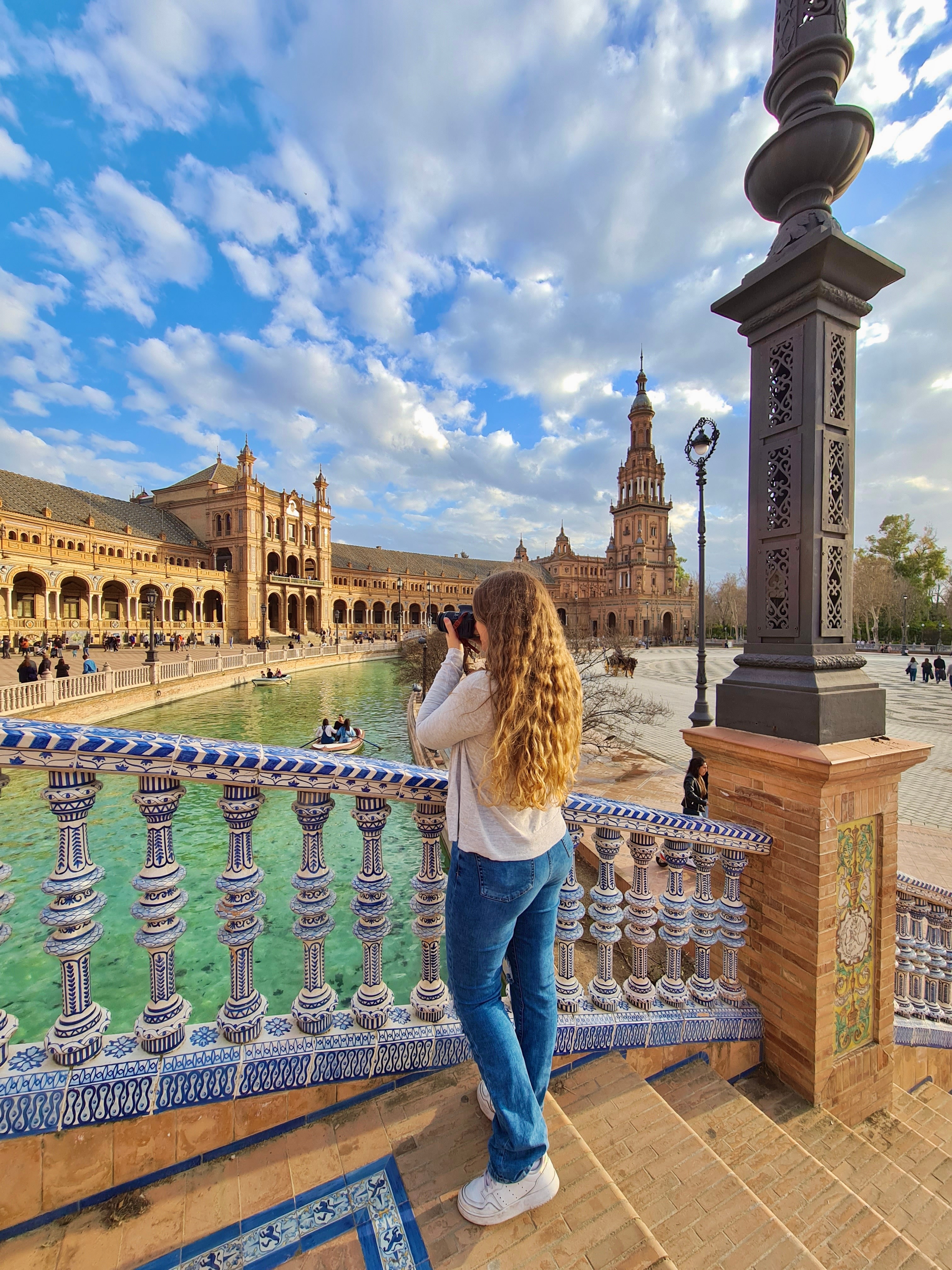 Kaitlin taking a photo from a bridge in Seville’s Plaza de Espana on a sunny day