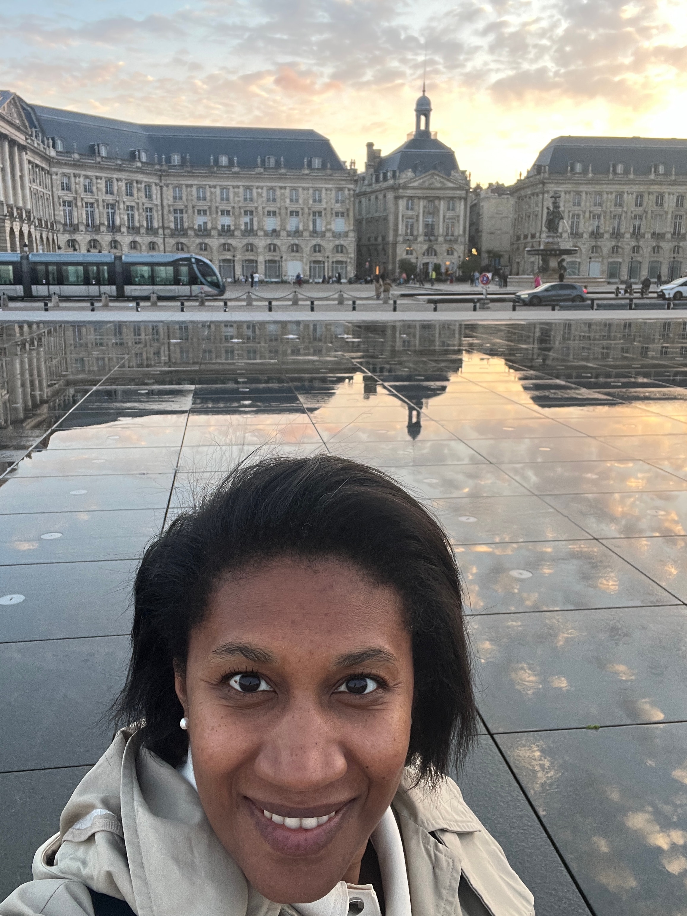 Advisor posing for an image with classic buildings in the distance at dusk.