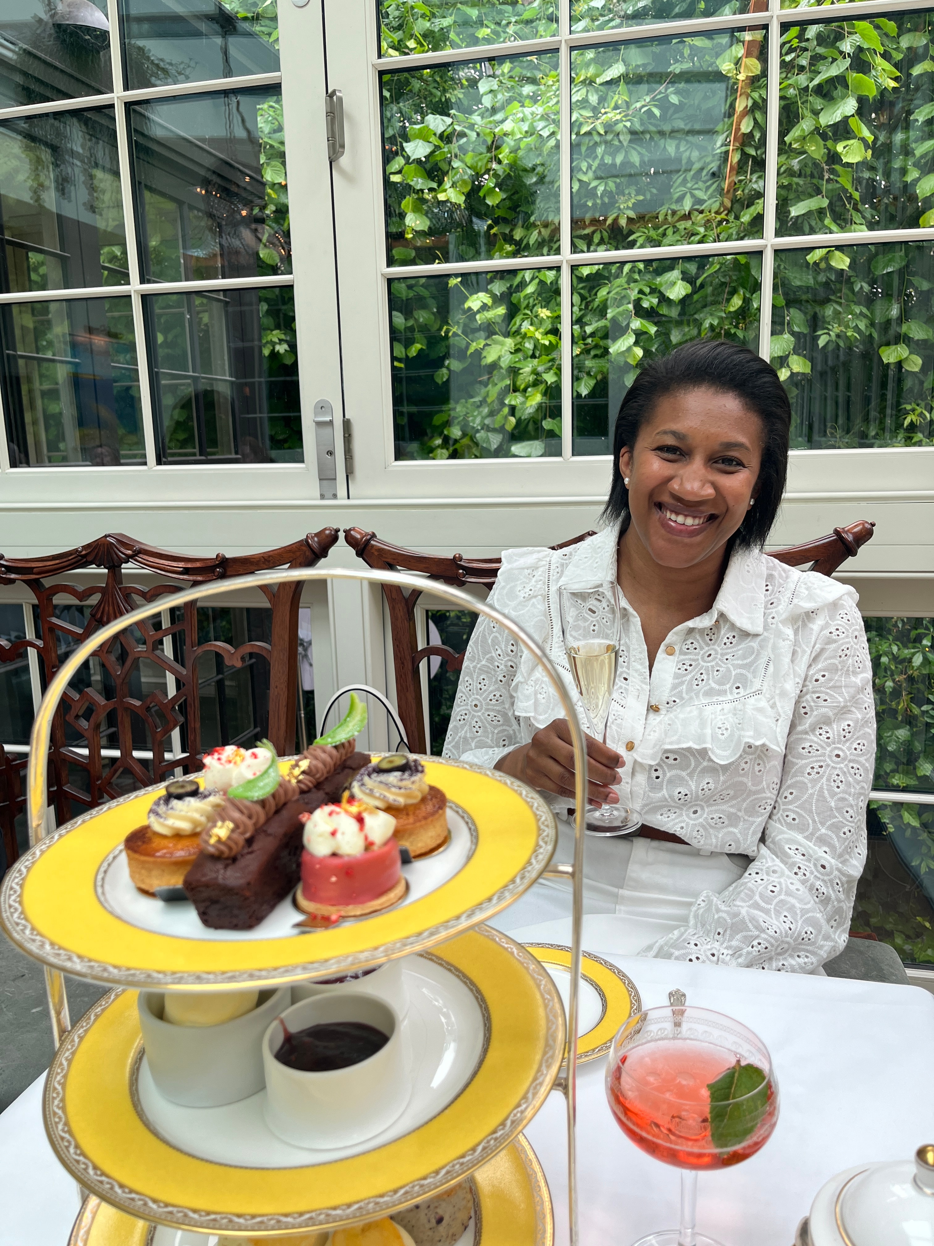 Advisor posing at afternoon tea with desserts on a platter.