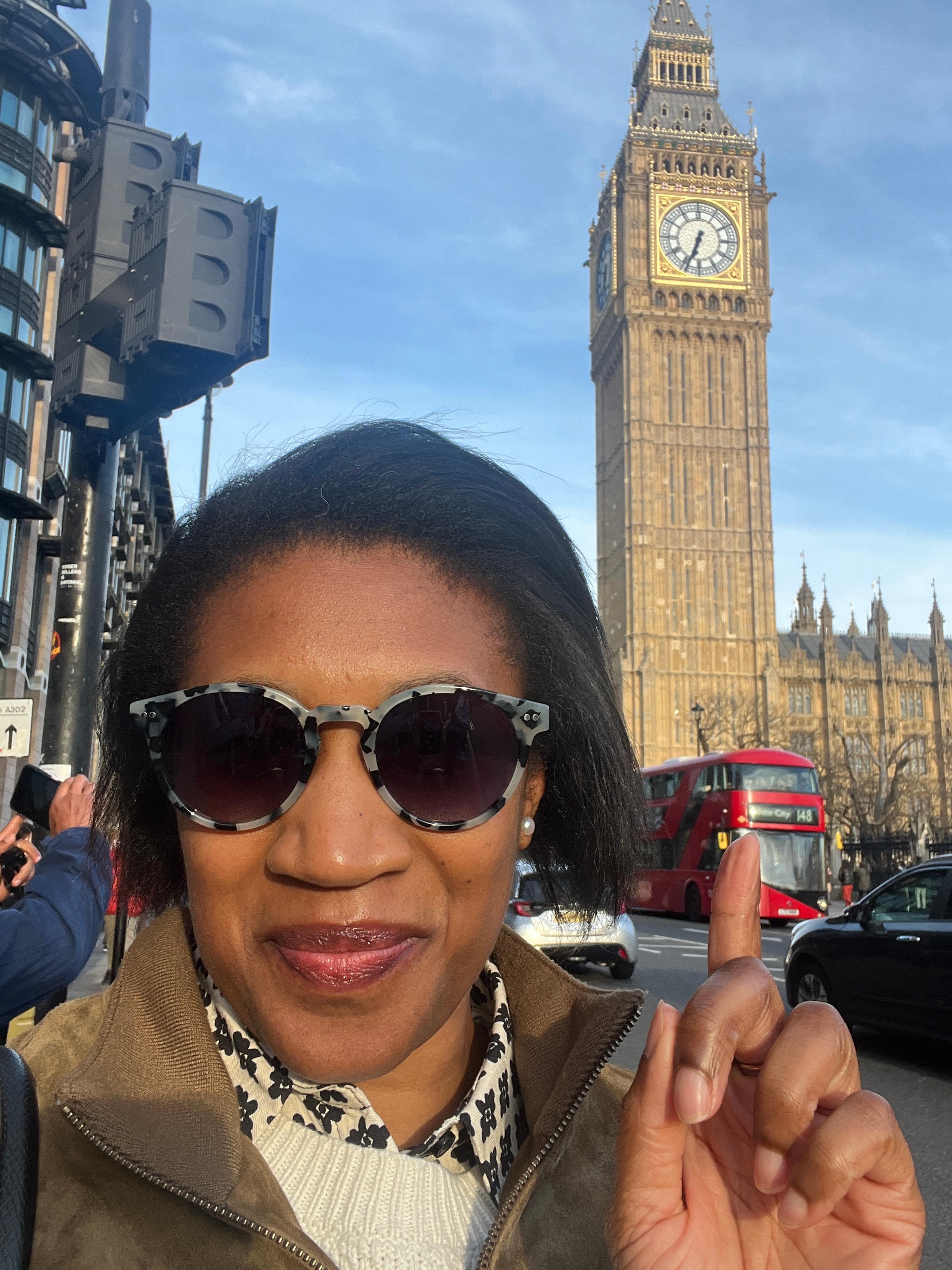 Advisor posing for an image with classic architecture in the distance on a sunny day.