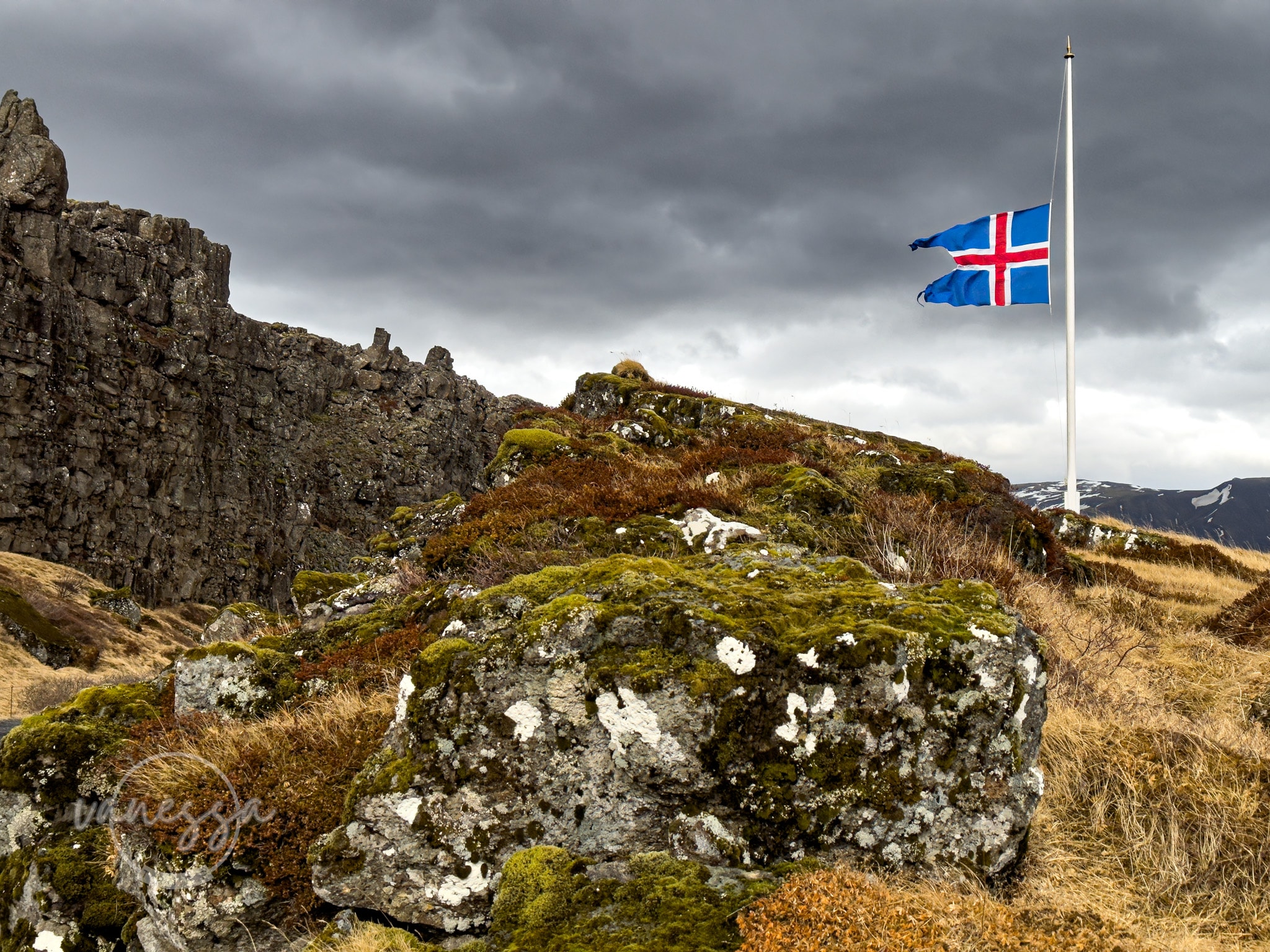 A image of the top of a mountain with a UK flag on a cloudy day.