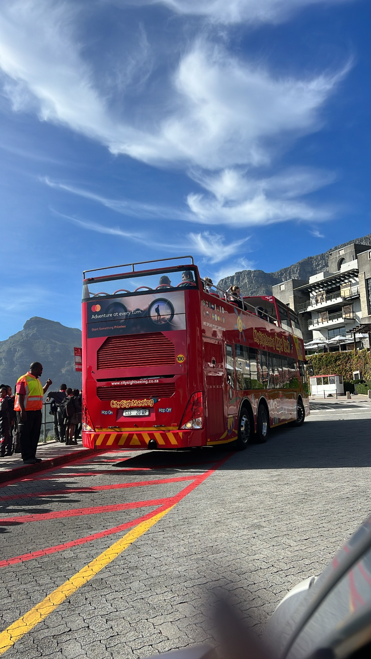 View of the back of a red double decker bus on the road on a sunny day