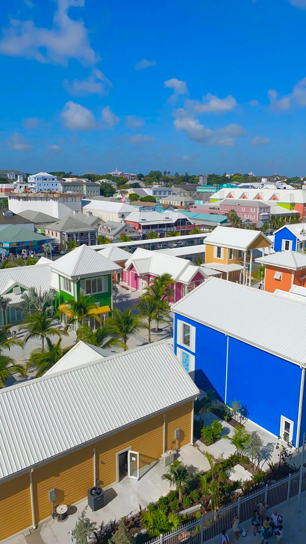 An aerial view of colorful houses in a suburban region during the daytime with clouds in the distance. 