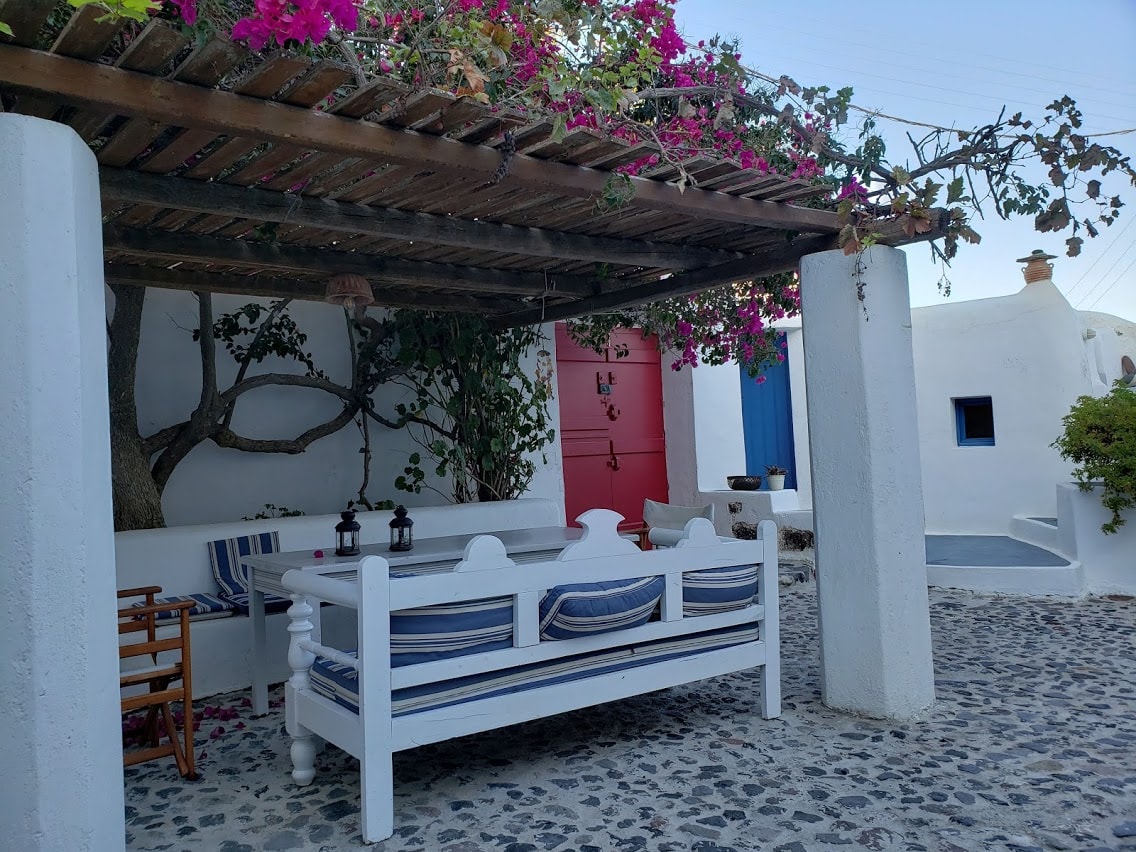 A beautiful view of outdoor seating at dusk with lush foliage and flowers. 