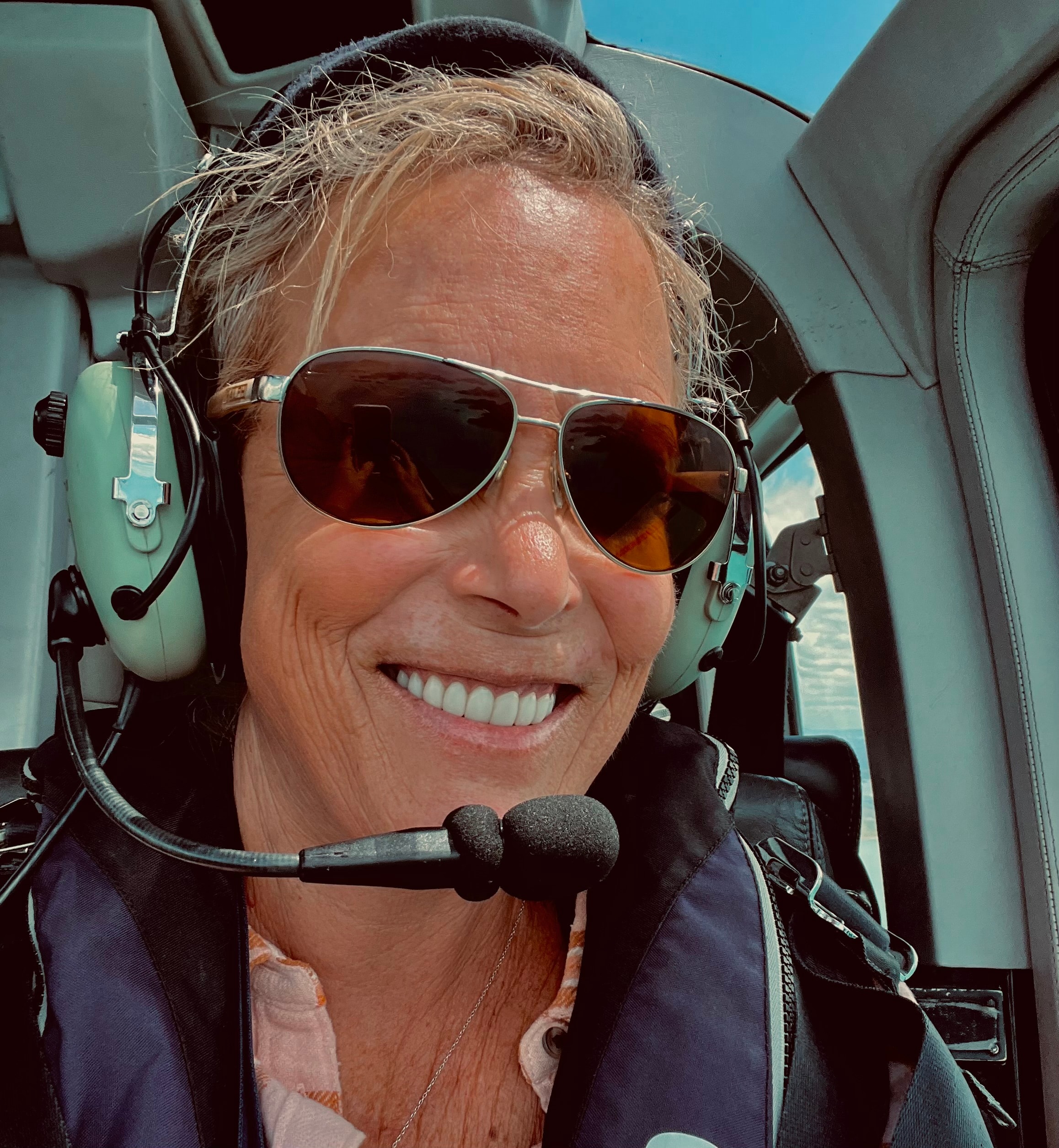 Lisa in sunglasses and a large headset with microphone taking a selfie