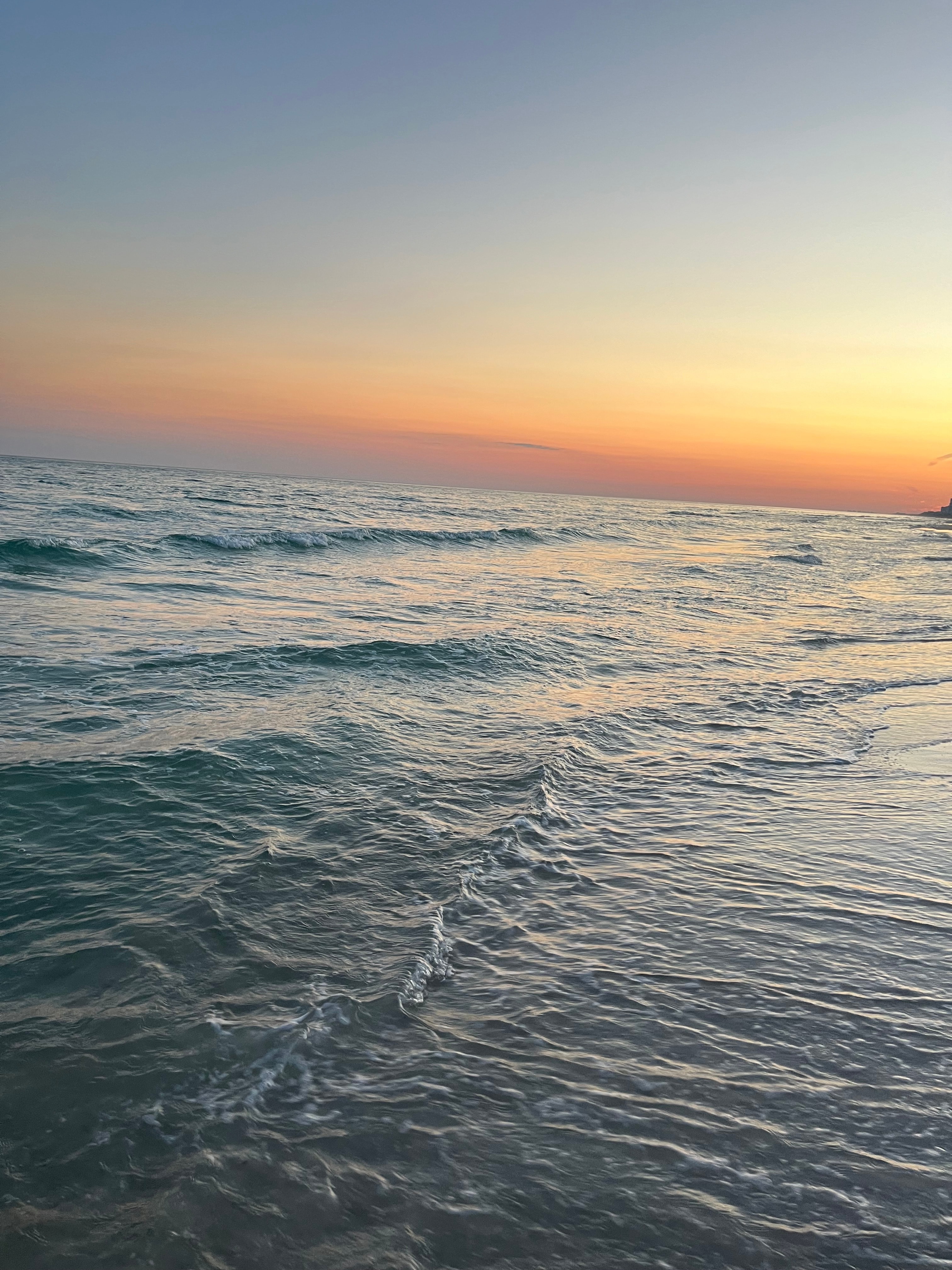 The ocean waves at sunset.