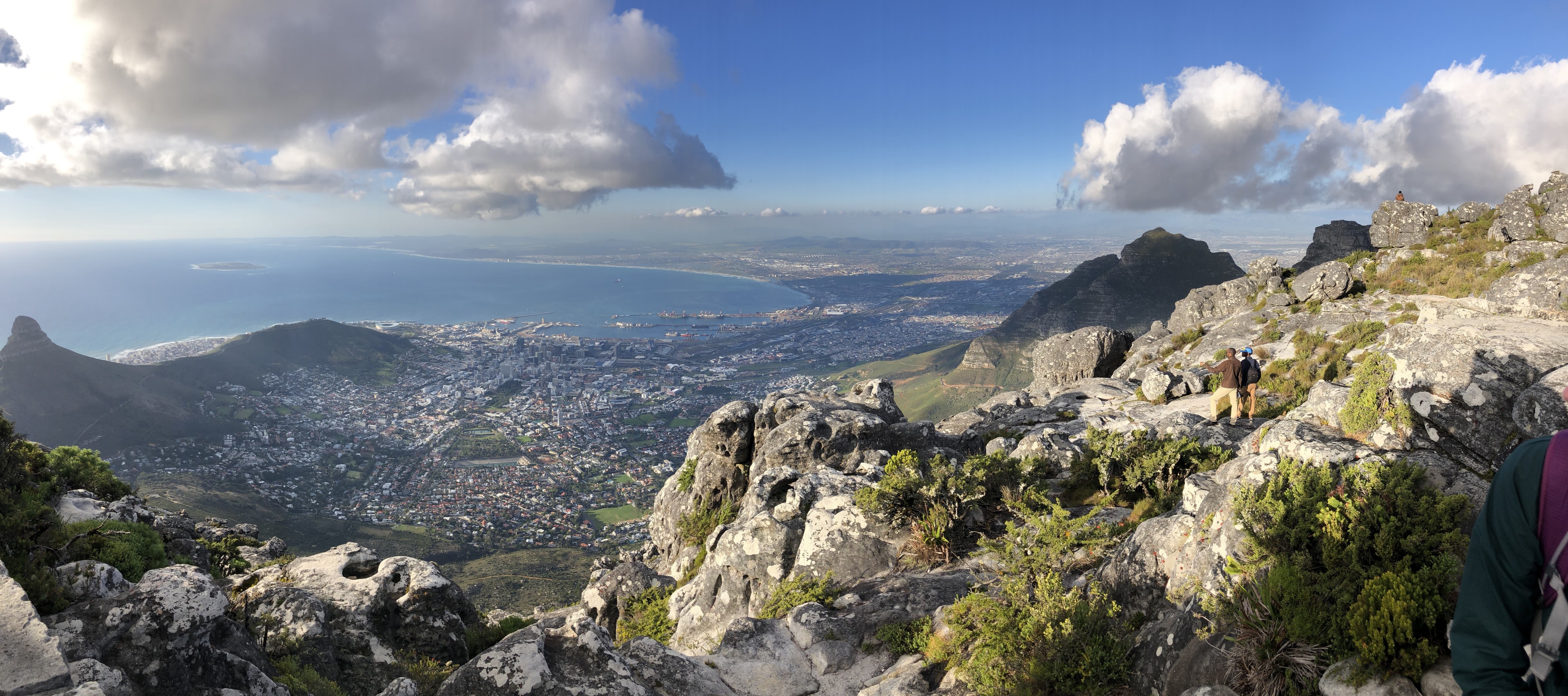 An aerial view of a hiking area with a deep mountain range below on a sunny day. 